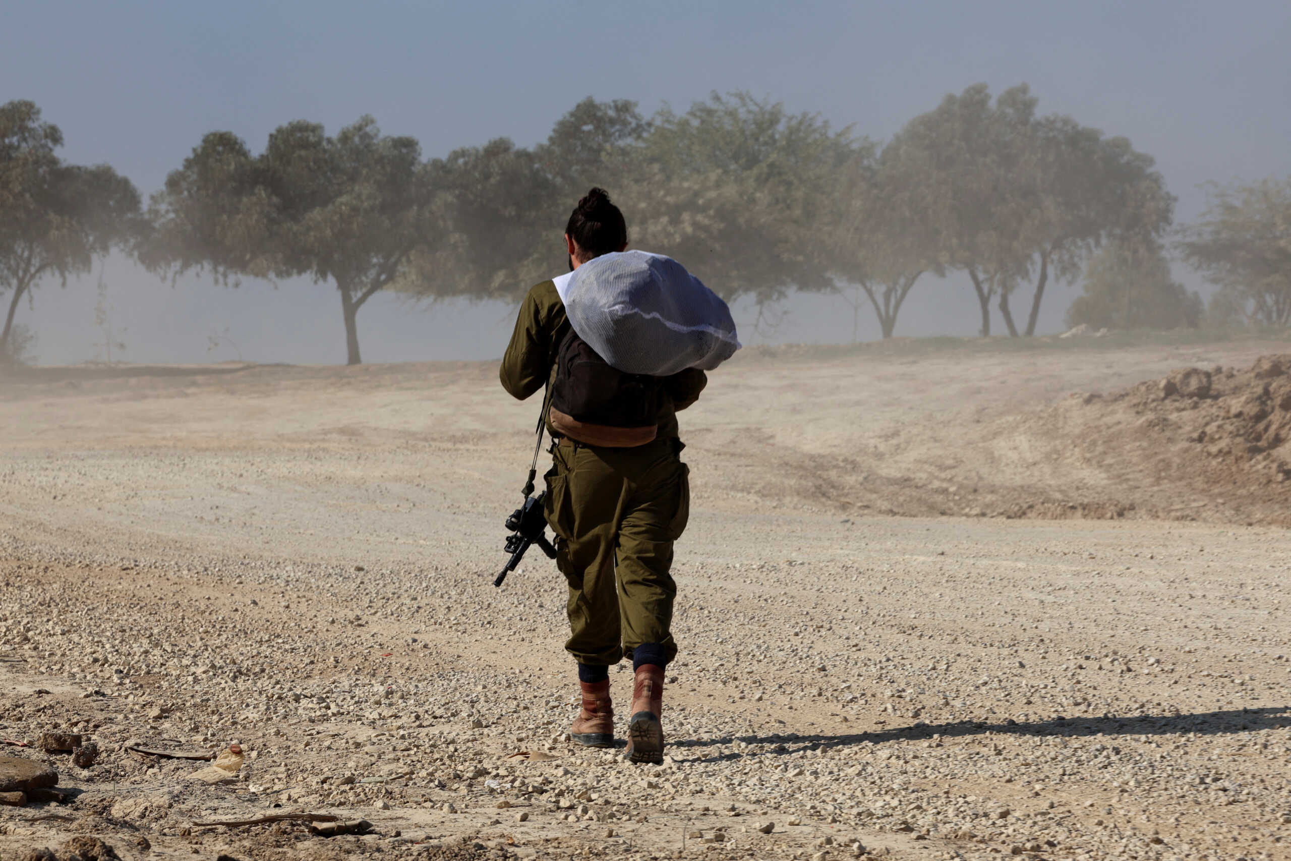 An Israeli soldier walks near the Israel-Gaza border, amid the ongoing conflict between Israel and the Palestinian Islamist group Hamas, in southern Israel, December 31, 2023. REUTERS