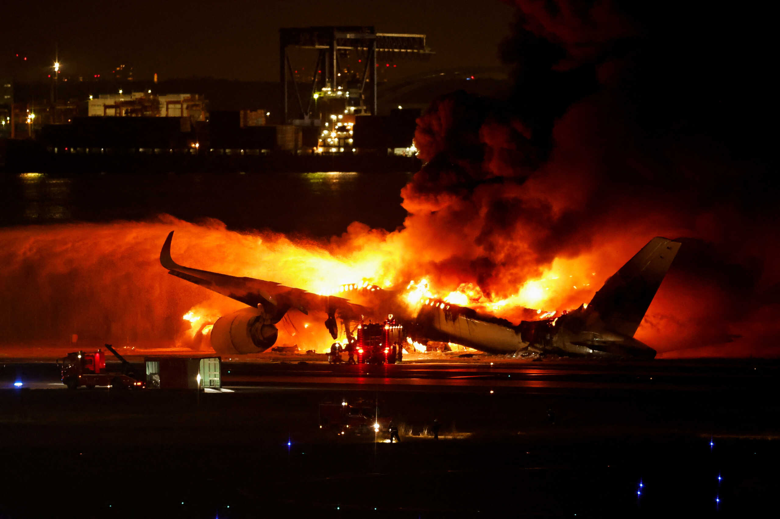 Firefighters work at Haneda International Airport after Japan Airlines' A350 airplane caught on fire,  in Tokyo, Japan January 2, 2024. REUTERS
