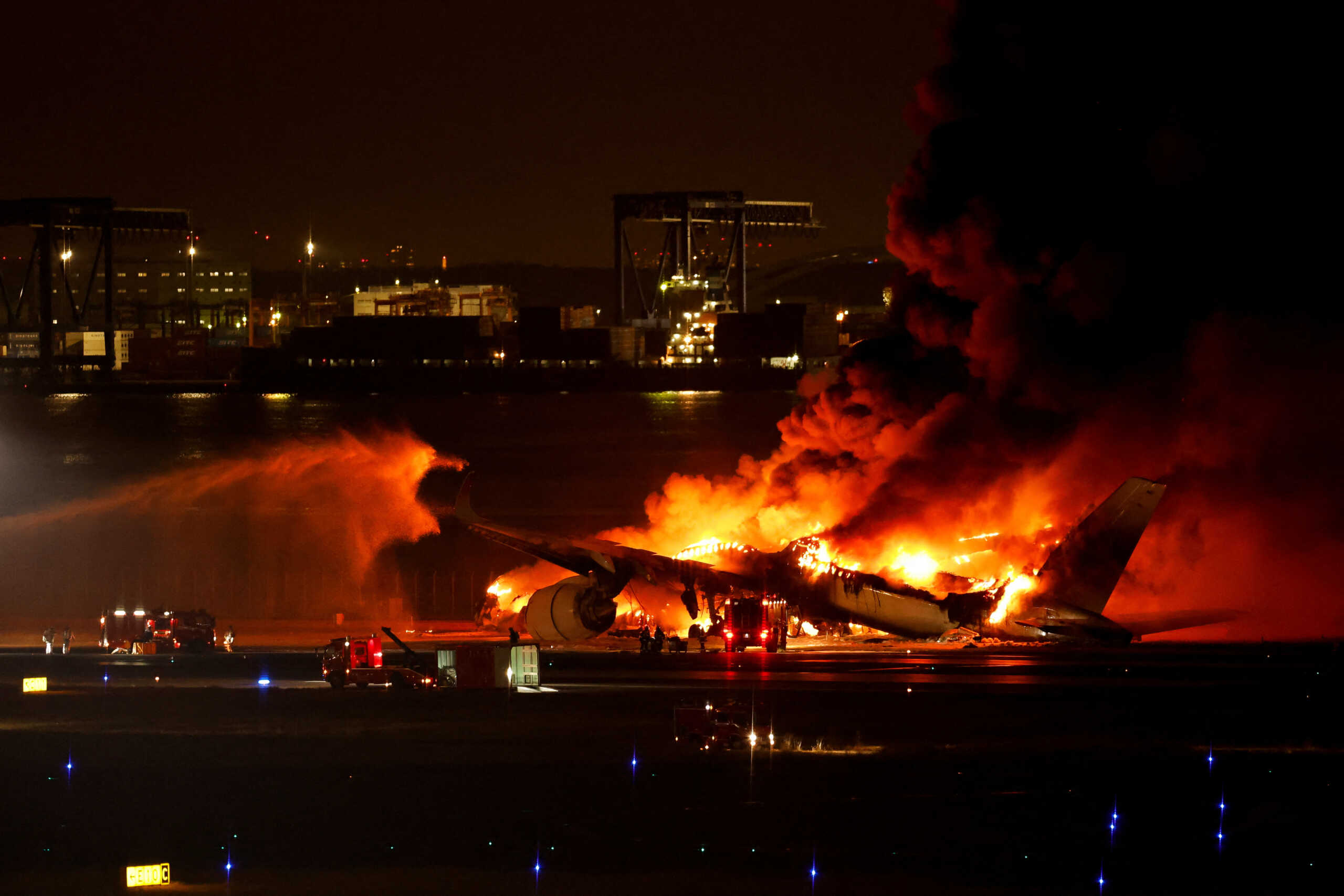 Firefighters work at Haneda International Airport after Japan Airlines' A350 airplane caught on fire,  in Tokyo, Japan January 2, 2024. REUTERS