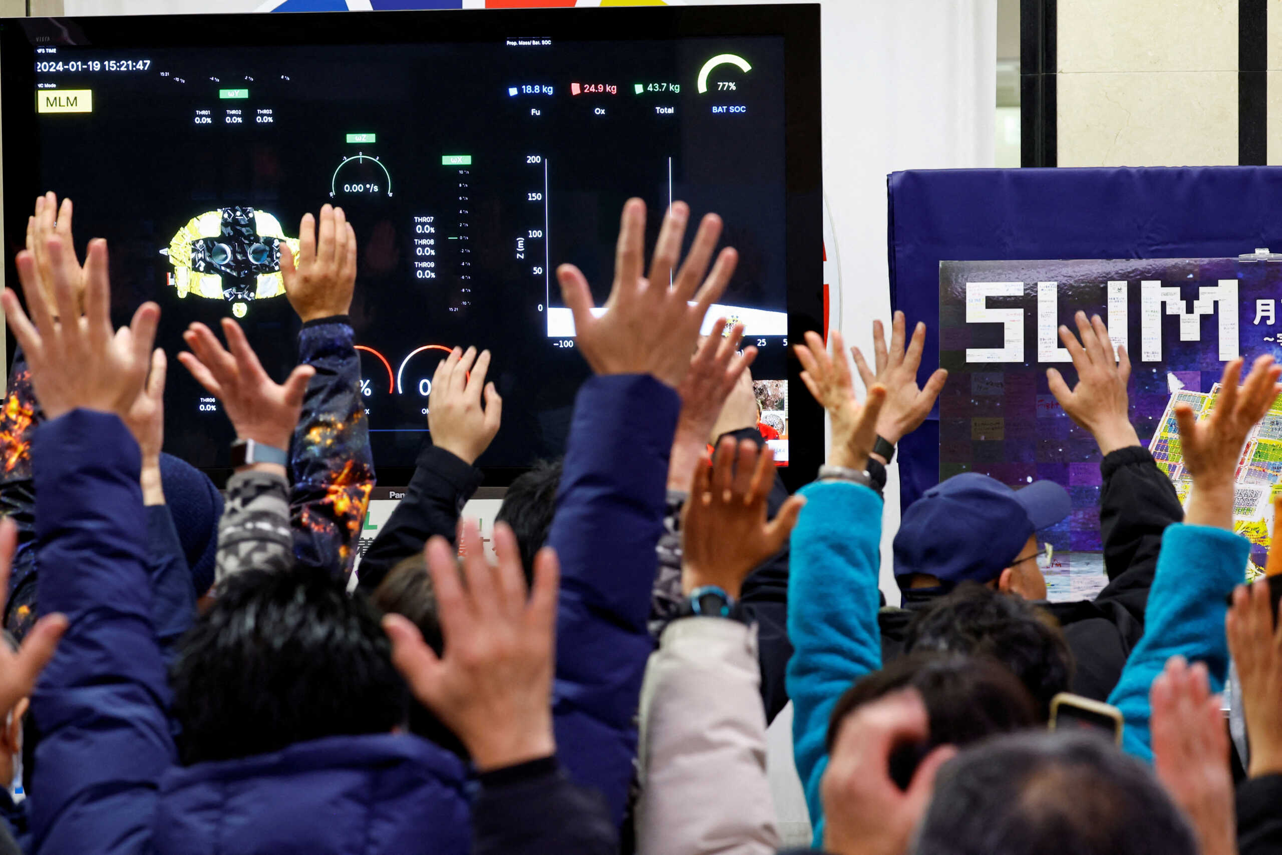 People raise their hands after a moon landing by the Smart Lander for Investigating Moon (SLIM), in a public viewing event in Sagamihara, south of Tokyo, Japan January 20, 2024. REUTERS