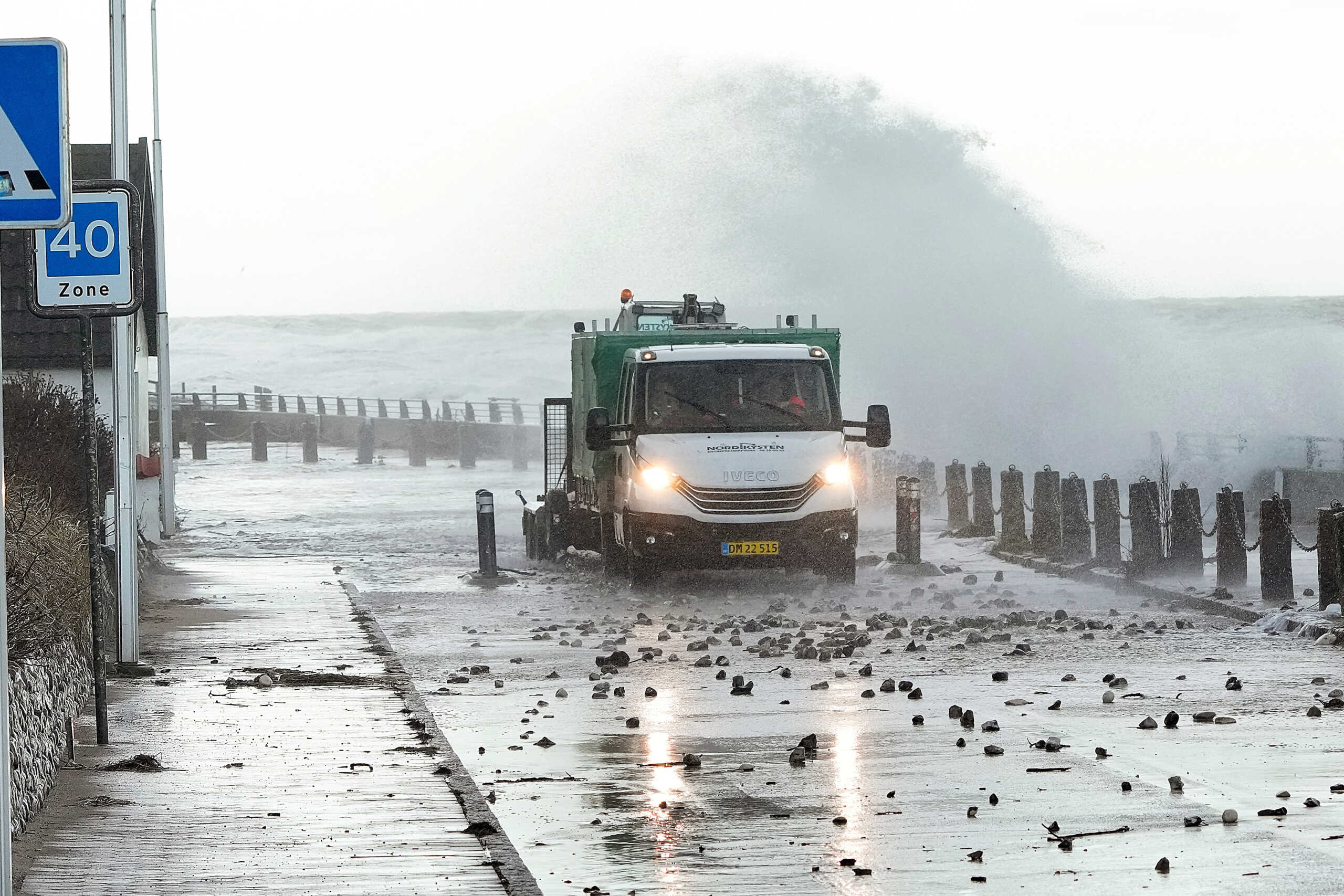 A van moves on flooded a coastal road as waves hit the shore amid high tides and flooding caused by Storm Pia, which hit Denmark on Thursday, in Raageleje, Denmark, December 22, 2023. Ritzau Scanpix