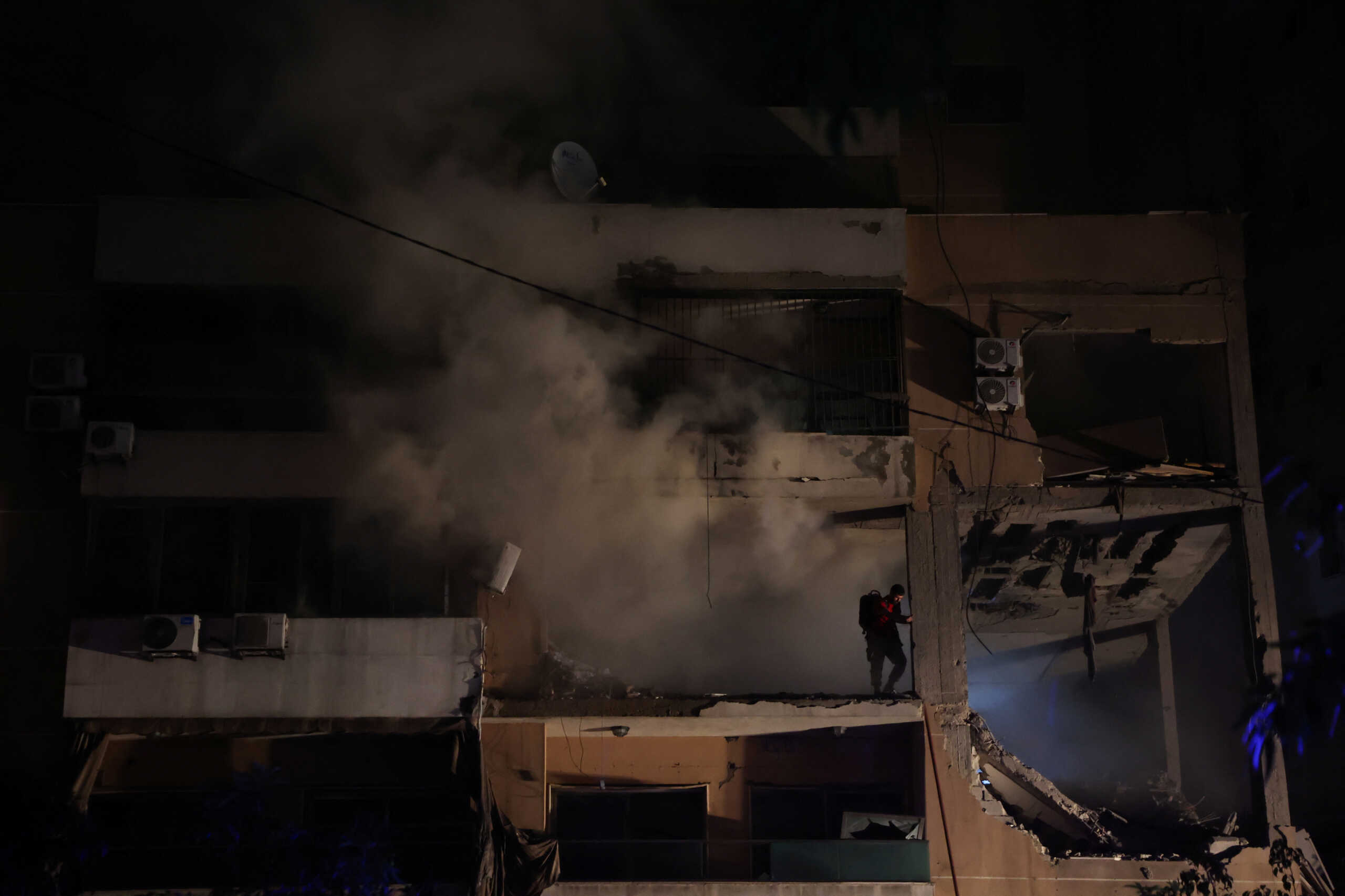 Smoke rises as a man stands on a damaged building at the site of an explosion, in what security sources say is an Israeli drone strike, in the Beirut suburb of Dahiyeh, Lebanon January 2, 2024. REUTERS