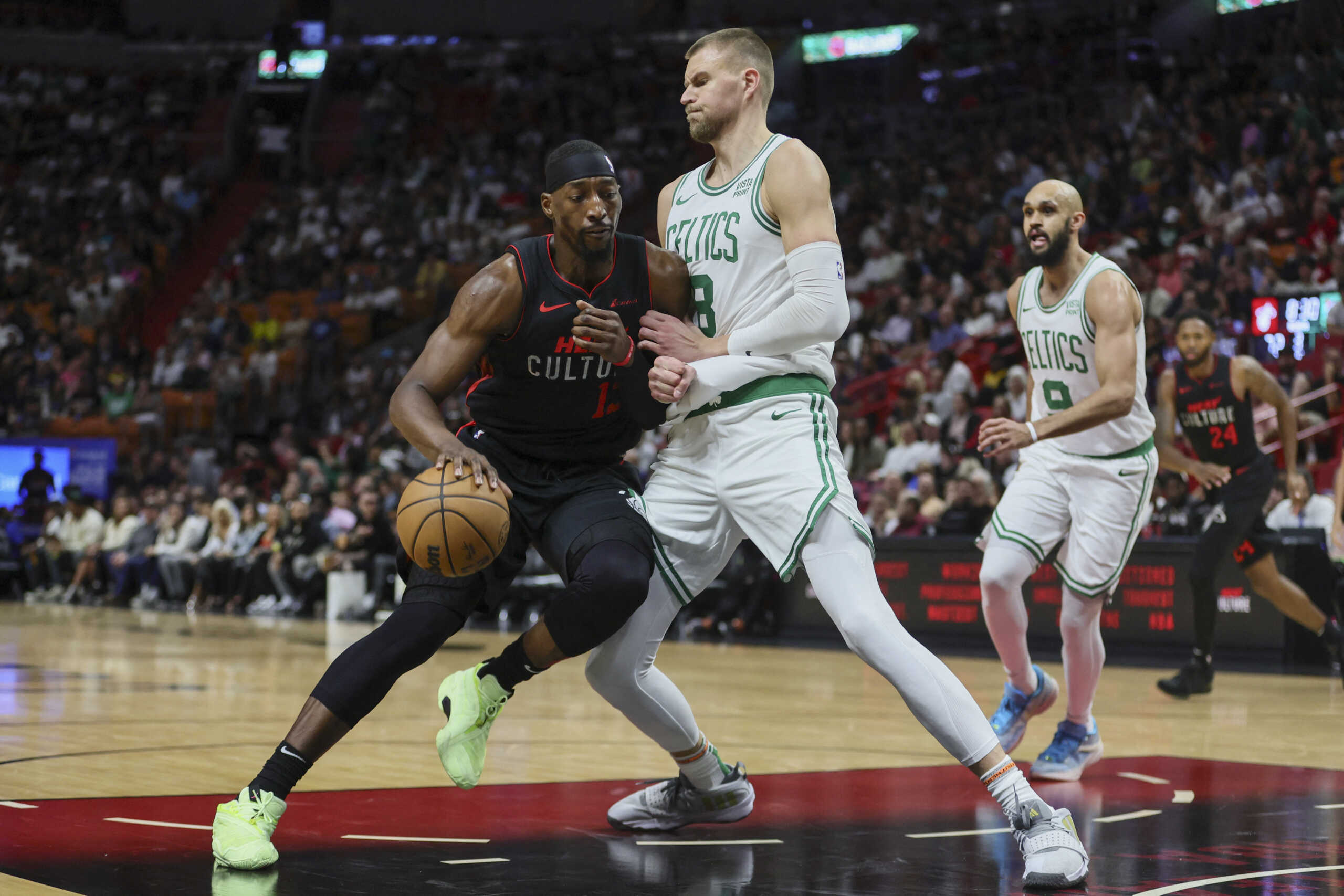 Jan 25, 2024; Miami, Florida, USA; Miami Heat center Bam Adebayo (13) drives to the basket against Boston Celtics center Kristaps Porzingis (8) during the third quarter at Kaseya Center. Mandatory Credit: Sam Navarro-USA TODAY Sports