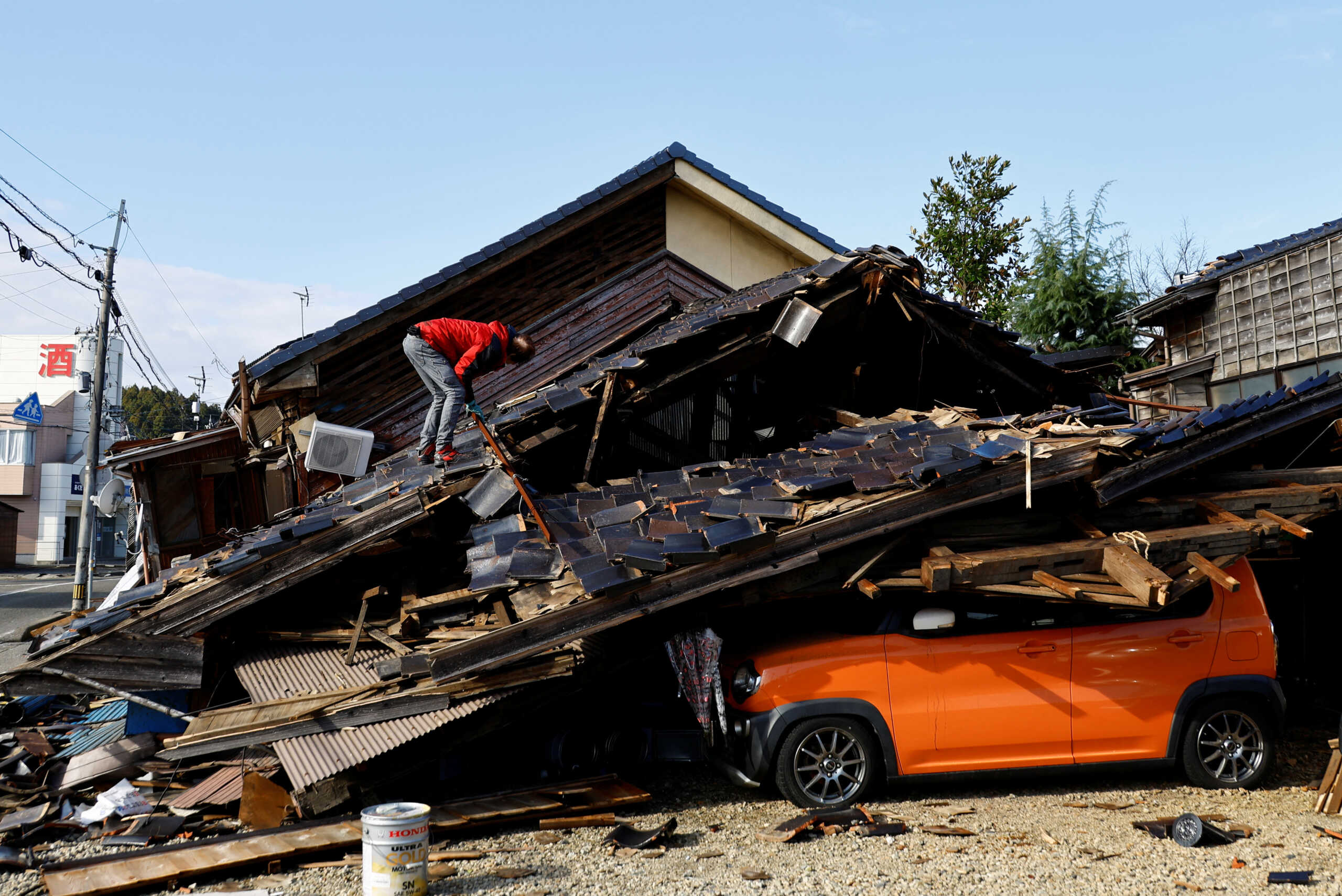 Hiroshi Omukai looks for his computer at his damaged car repair shop, in the aftermath of an earthquake, in Wajima, Ishikawa Prefecture, Japan, January 5, 2024. REUTERS