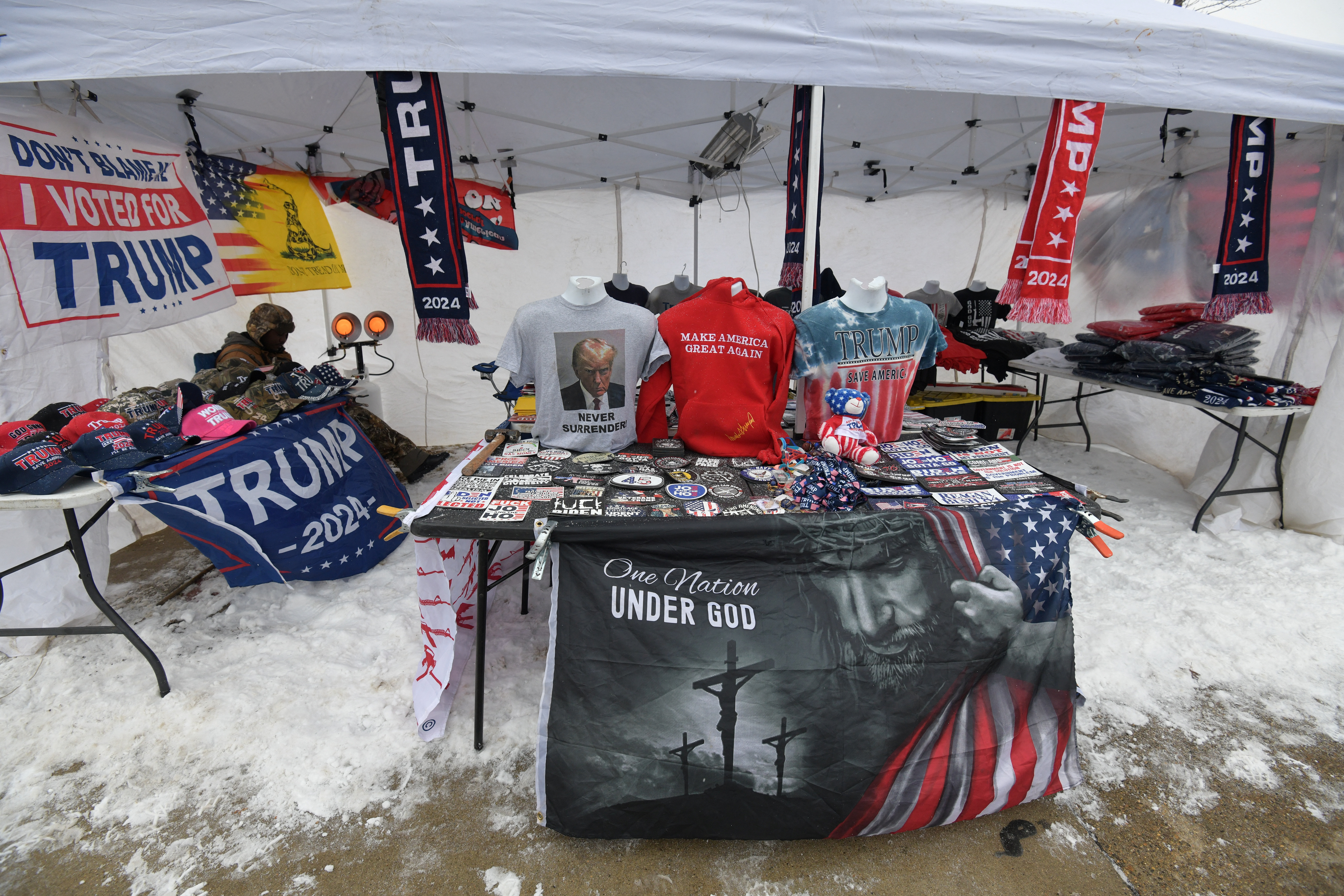 A vendor sits while selling merchandise ahead of a rally with Republican presidential candidate and former U.S. President Donald Trump at the Southern New Hampshire University Arena in Manchester, New Hampshire, U.S. January 20, 2024.  REUTERS