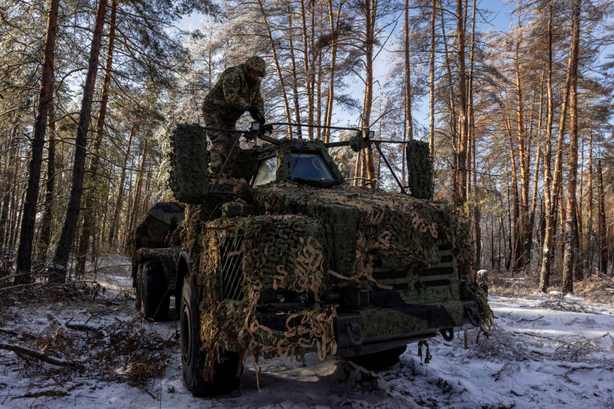 A serviceman of Ukraine's 45th separate artillery brigade stands atop a Swedish-made Archer self-propelled howitzer system in a forest in the Donetsk region, amid Russia's attack on Ukraine, December 16, 2023.  REUTERS