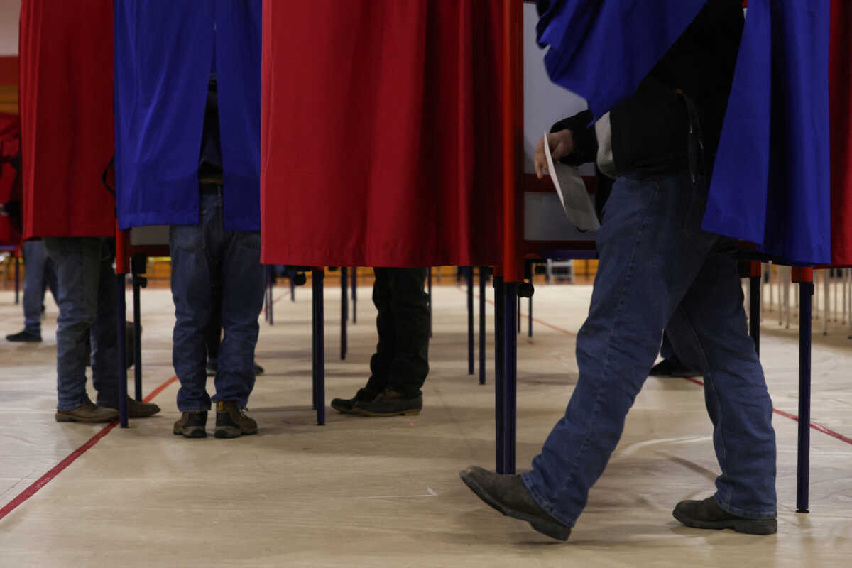 People fill out their ballots in voting booths during the New Hampshire presidential primary election, at Pinkerton Academy in Derry, New Hampshire, U.S., January 23, 2024. REUTERS