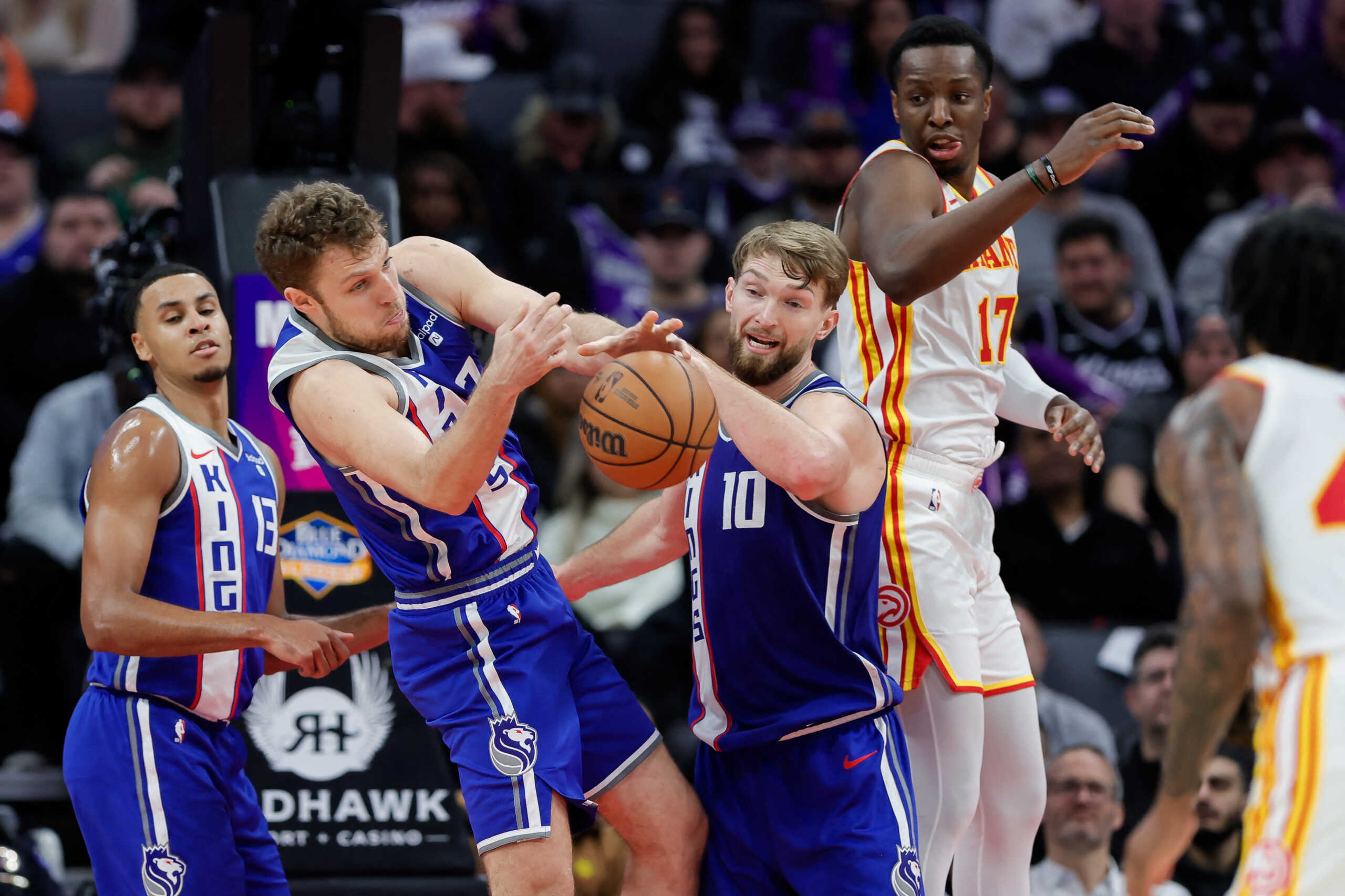 Jan 22, 2024; Sacramento, California, USA; Sacramento Kings forward Sasha Vezenkov (7) and forward Domantas Sabonis (10) reach for the ball during the third quarter against the Atlanta Hawks at Golden 1 Center. Mandatory Credit: Sergio Estrada-USA TODAY Sports