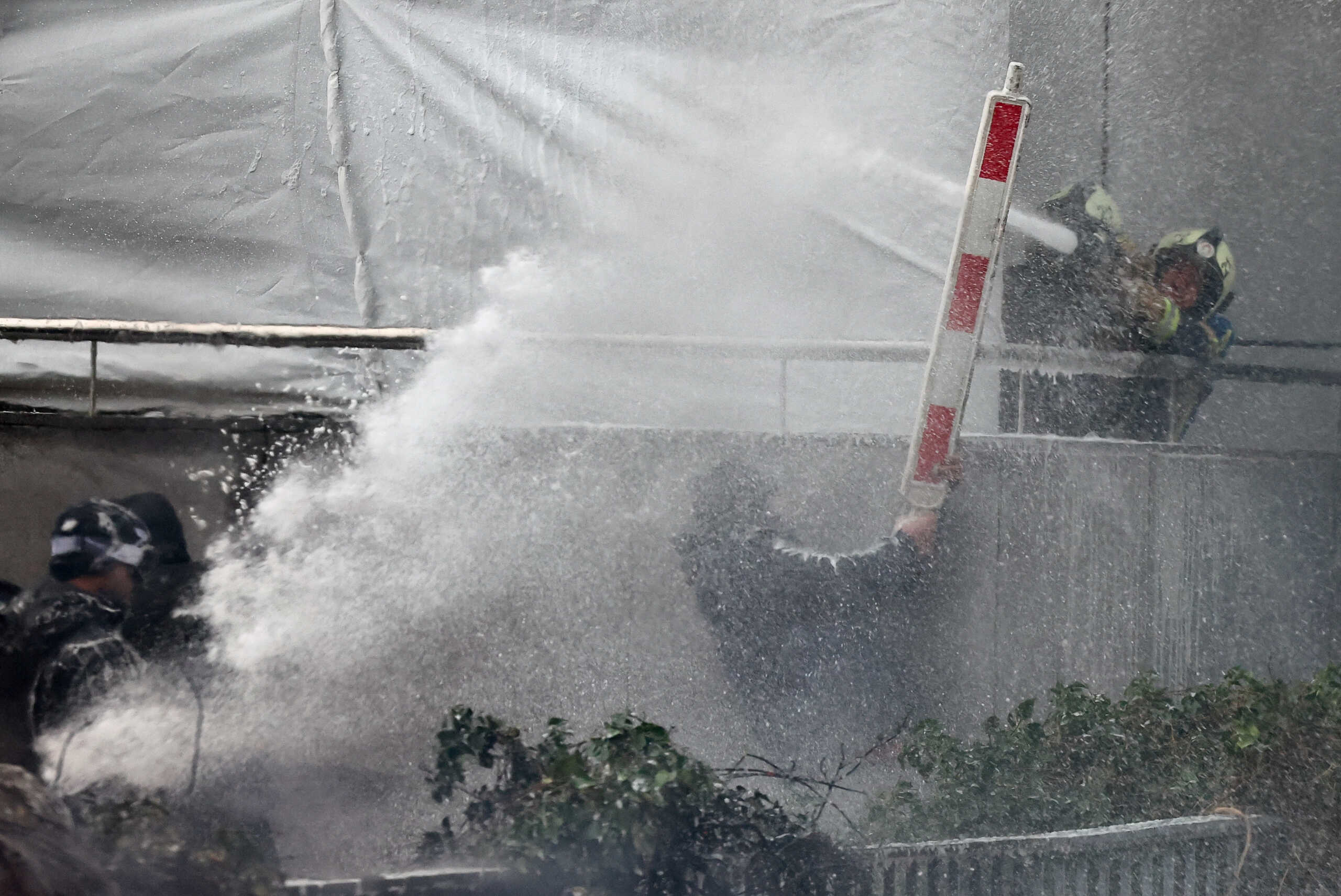 Water is sprayed on demonstrators during a protest of European farmers over price pressures, taxes and green regulation, on the day of an EU Agriculture Ministers meeting in Brussels, Belgium February 26, 2024. REUTERS