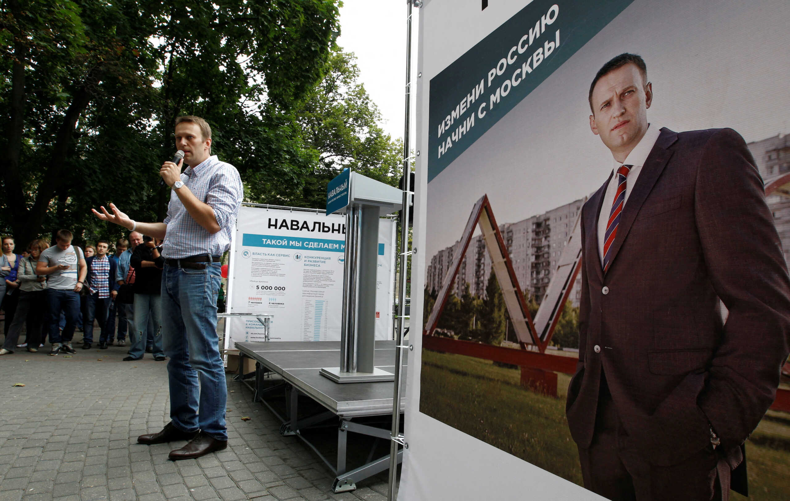FILE PHOTO: Russia's opposition leader and anti-graft blogger Alexei Navalny (C) speaks in Moscow July 30, 2013. Navalny is campaigning for the September 8 Moscow mayoral election. The board reads: "Change Russia. Start from Moscow". REUTERS