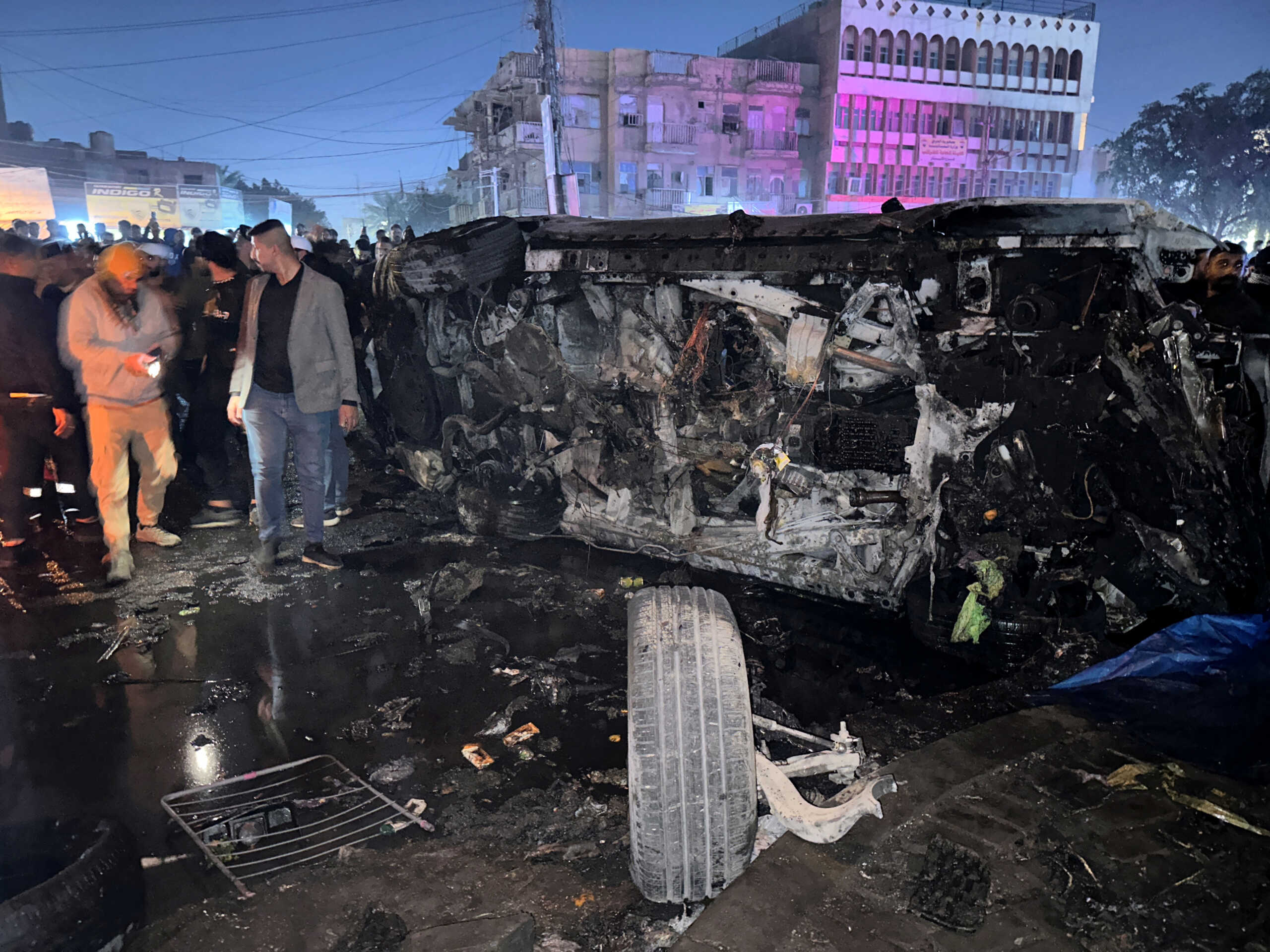 People inspect a vehicle, after what security sources said was a deadly drone strike, in Baghdad, Iraq, February 7, 2024. REUTERS