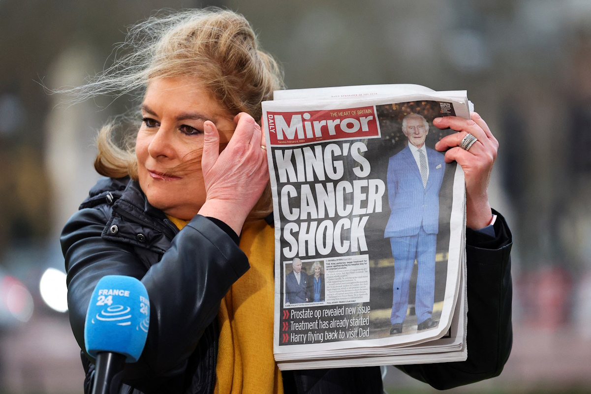 A member of the media holds a copy of the "Daily Mirror" newspaper while working outside Buckingham Palace, after it was announced that Britain's King Charles has been diagnosed with cancer, in London, Britain, February 6, 2024. REUTERS