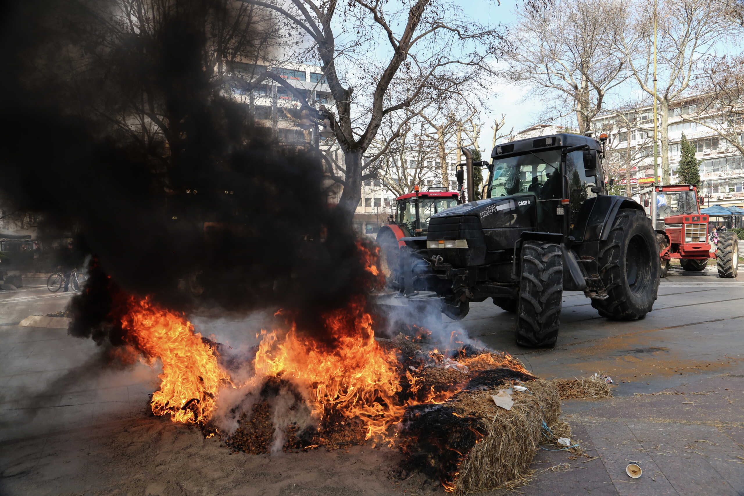 Λάρισα: Αγρότες έβαλαν φωτιά σε λάστιχα και άχυρα σε κεντρική πλατεία – Εικόνες από το σημείο