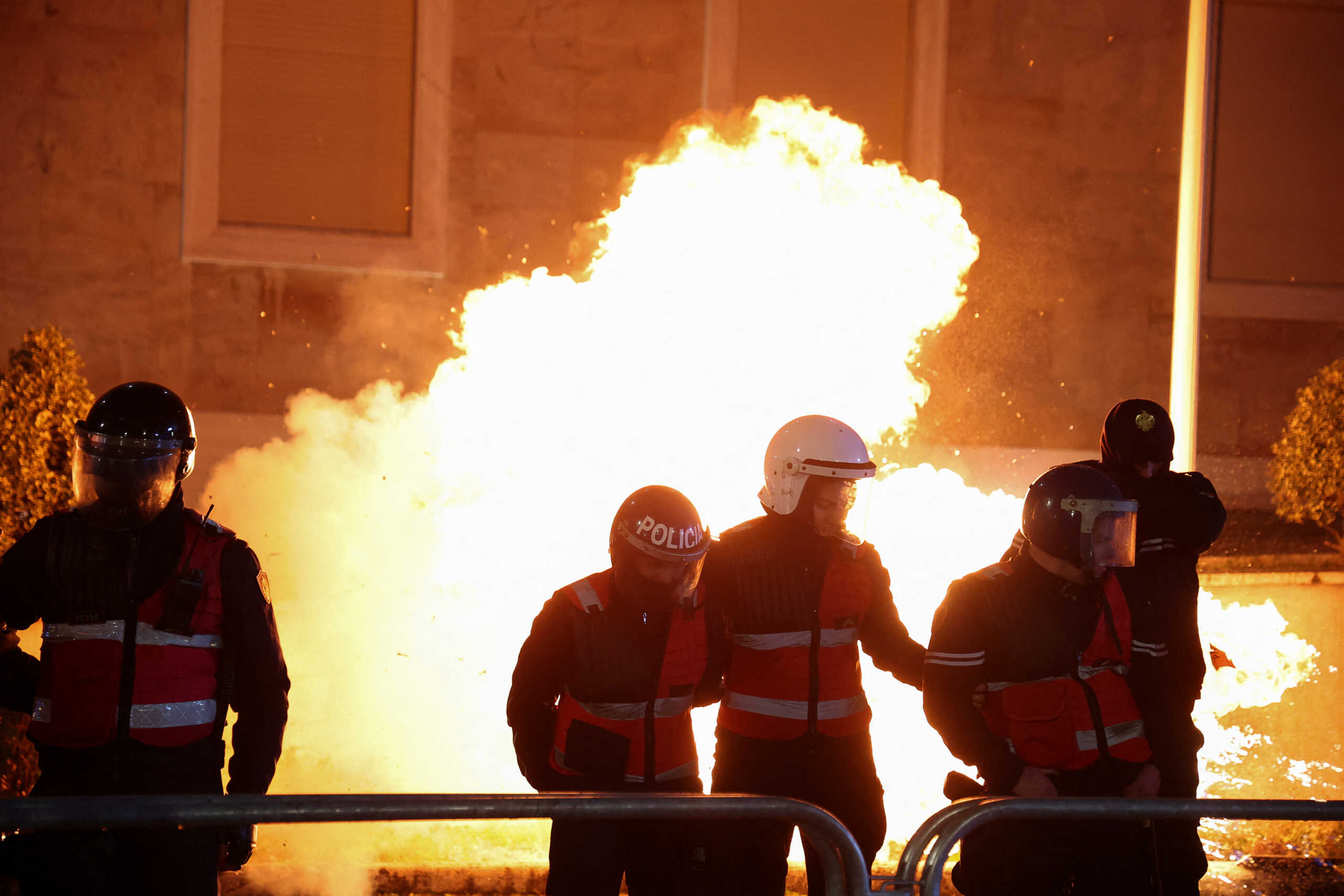 Police officers stand guard while a fire burns, as supporters of the opposition attend an anti-government protest in front of Prime Minister Edi Rama's office in Tirana, Albania, February 20, 2024. REUTERS