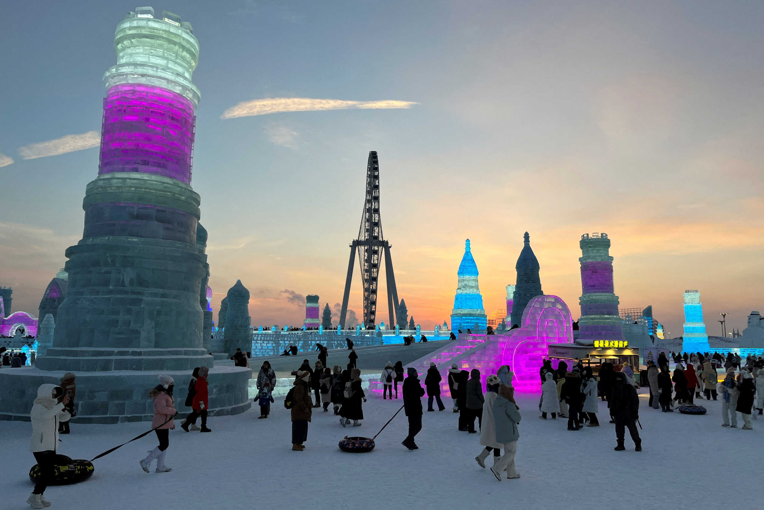 FILE PHOTO: Visitors walk past ice sculptures at the Harbin Ice and Snow Festival in Harbin, Heilongjiang province, China December 24, 2023. REUTERS