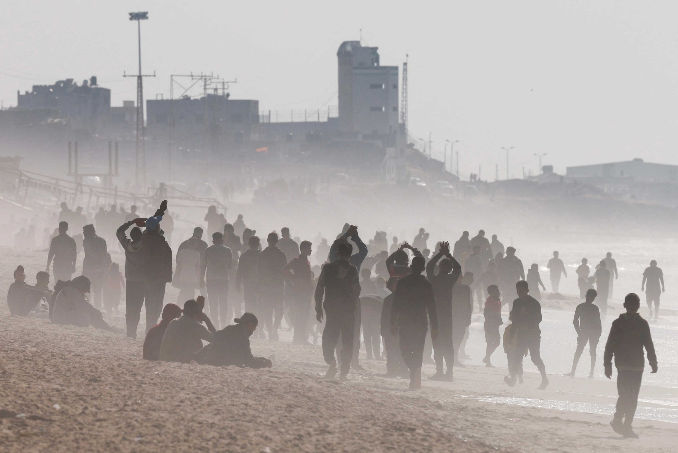 Palestinians gather on a beach in the hope of getting aid air-dropped over Gaza, amid the ongoing the conflict between Israel and Hamas, in the southern Gaza Strip February 27, 2024. REUTERS