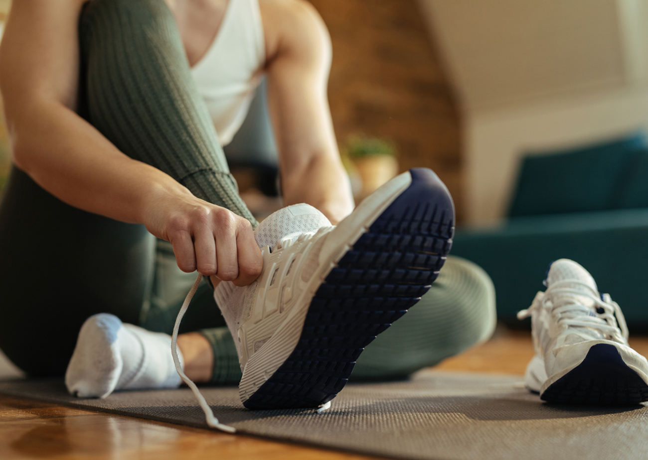 Close-up of sportswoman putting on sneakers.