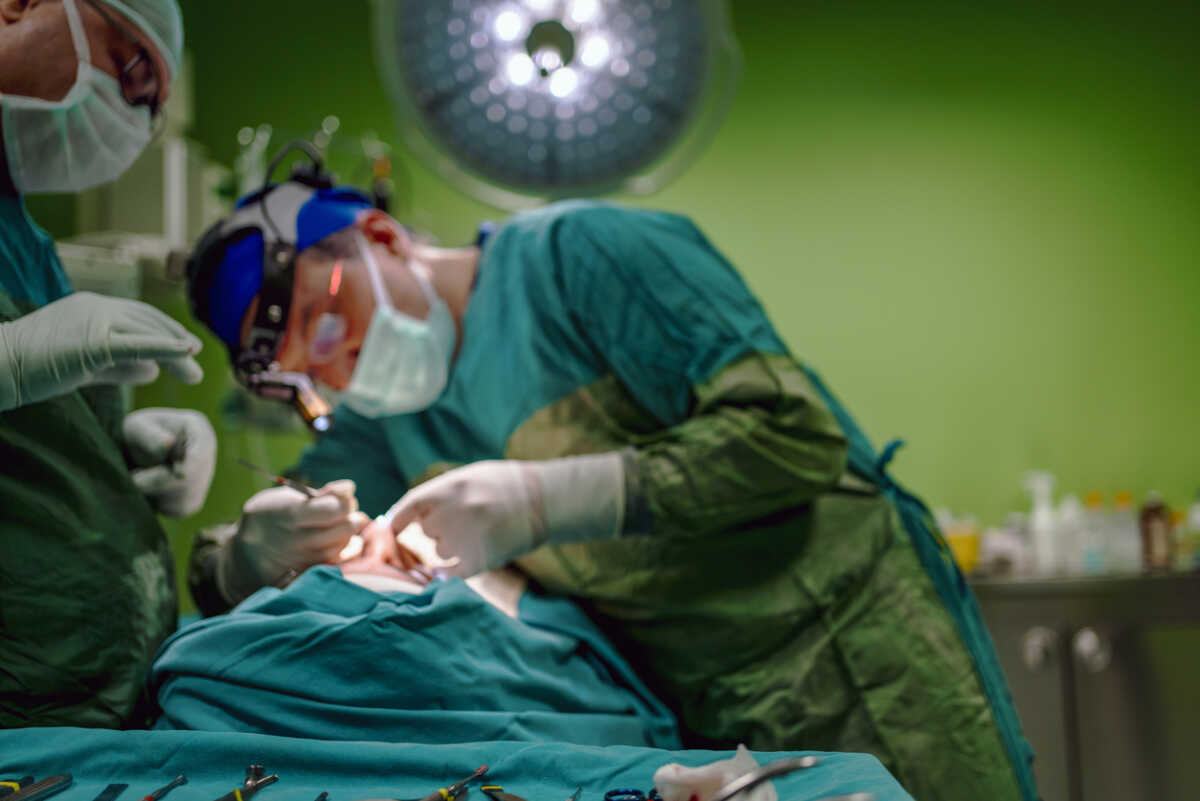 Young male plastic surgeon operates in the operating room of a medical center