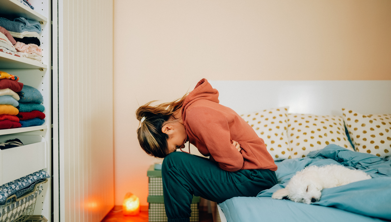 Young woman with painful menstruation resting in bed