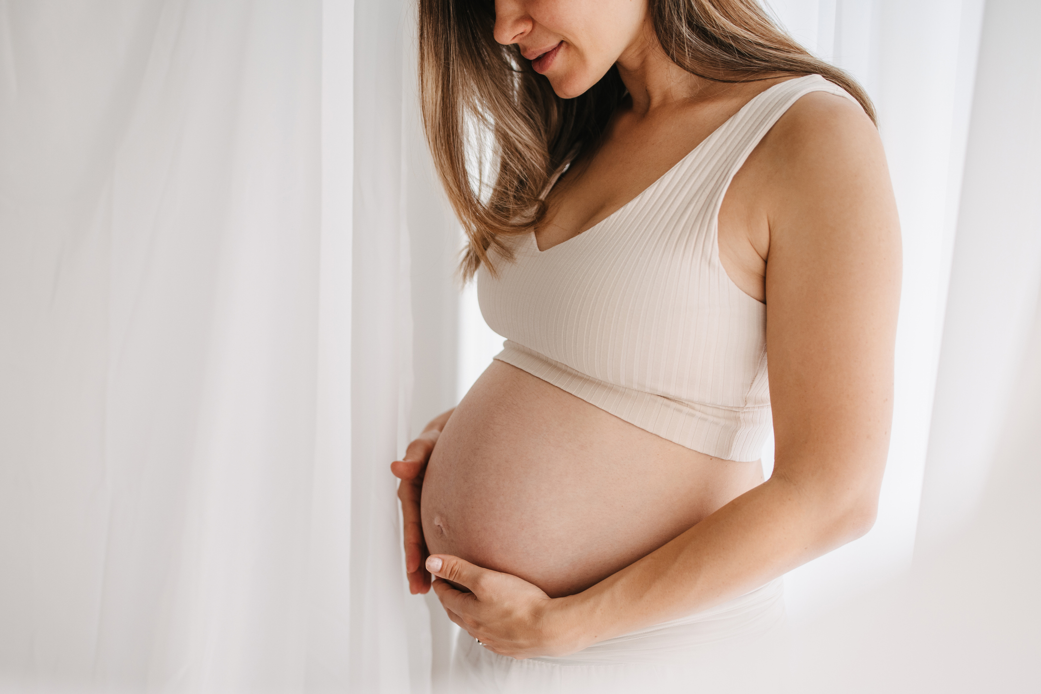 One woman, unrecognizable happy pregnant woman touching her belly.
