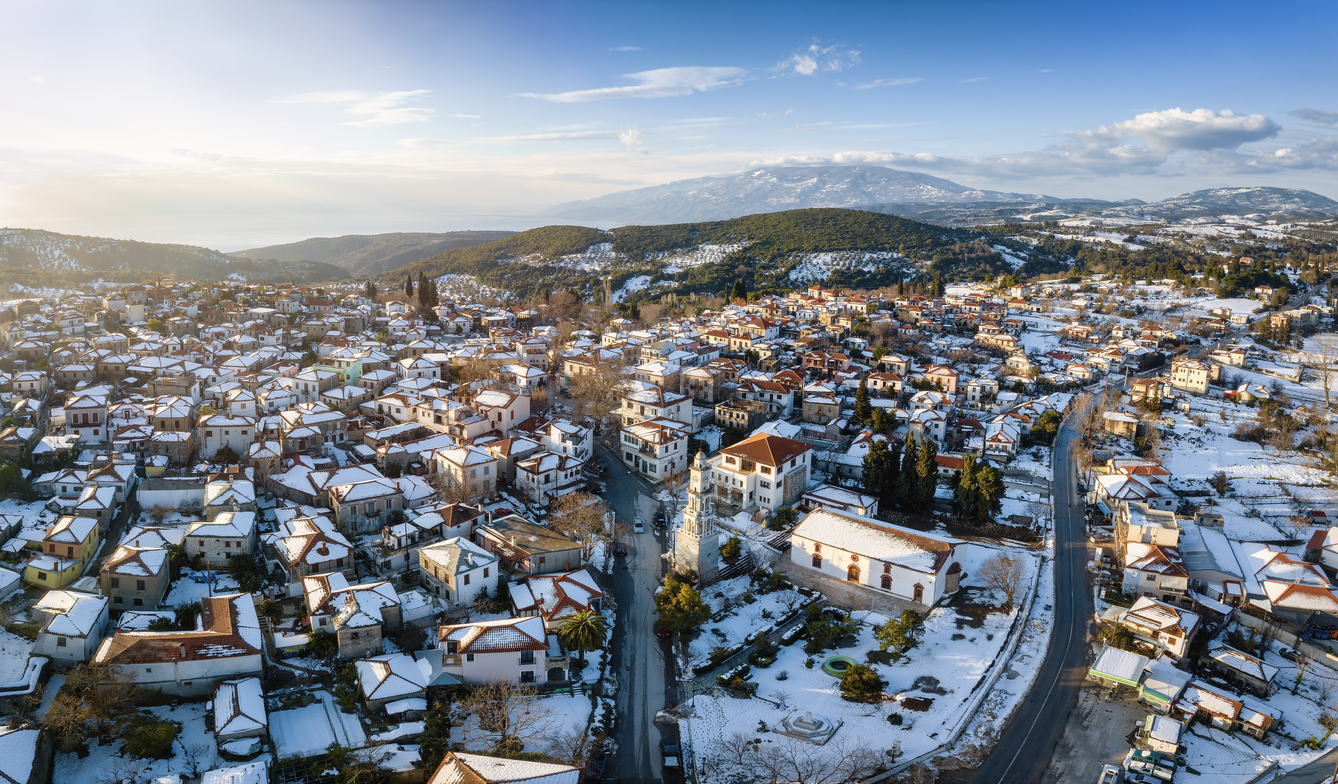 Panoramic aerial view of the snow covered village of Argalasti, Pelion, Greece, during a winter sunset