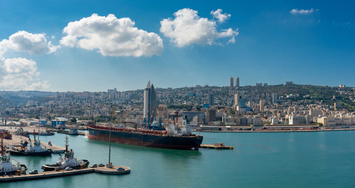 Haifa, Israel - Oct 10, 2022:  Port of Haifa , one of the three major international seaports in Israel, serves both passenger and merchant ships.  Baha'i Gardens is visible in the landscape background.
