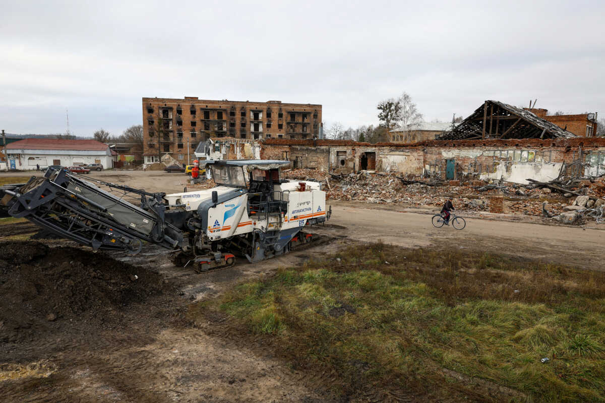 A local man rides on a bicycle past buildings, which were heavily damaged on the first months of Russia's attack on Ukraine in the town of Trostianets, Sumy region, Ukraine November 1, 2023. REUTERS
