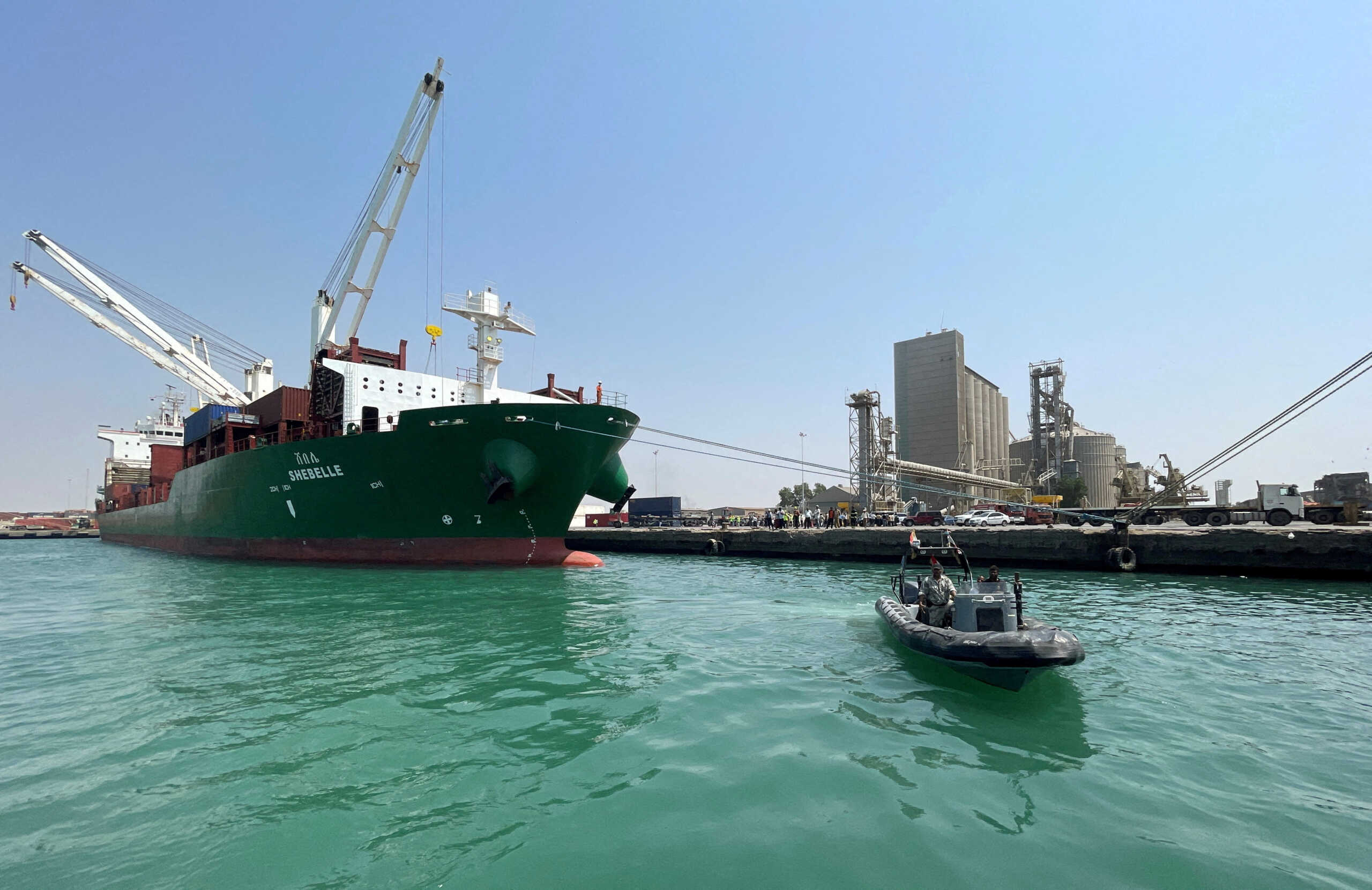 FILE PHOTO: A coastguard boat sails past a commercial container ship docked at the Houthi-held Red Sea port of Hodeidah, as a container ship carrying general commercial goods docked at the port for the first time since at least 2016, in Hodeidah, Yemen February 25, 2023. REUTERS