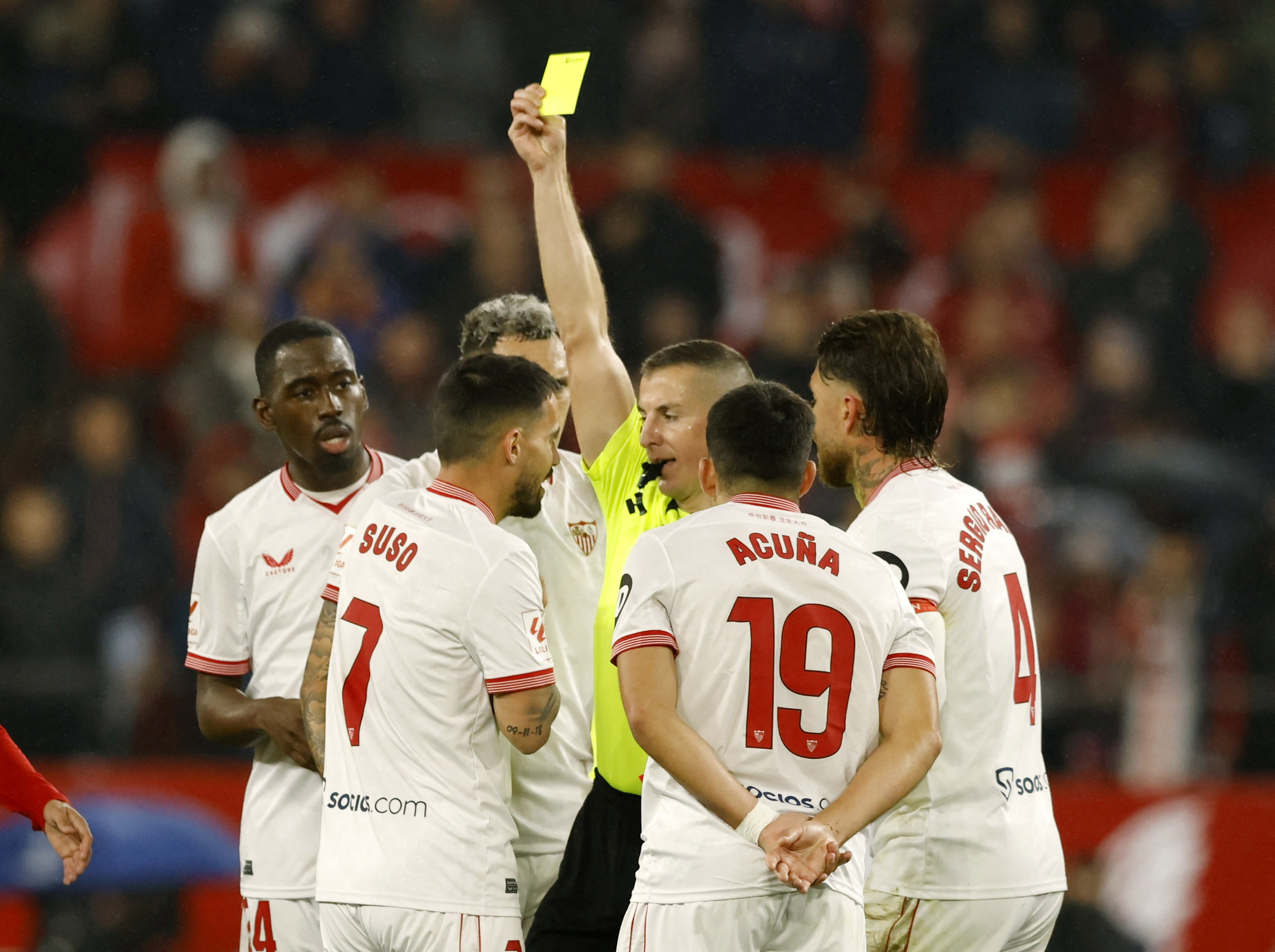 Soccer Football - LaLiga - Sevilla v Atletico Madrid - Estadio Ramon Sanchez Pizjuan, Seville, Spain - February 11, 2024 Sevilla's Suso is shown a yellow card by referee Javier Iglesias Villanueva REUTERS