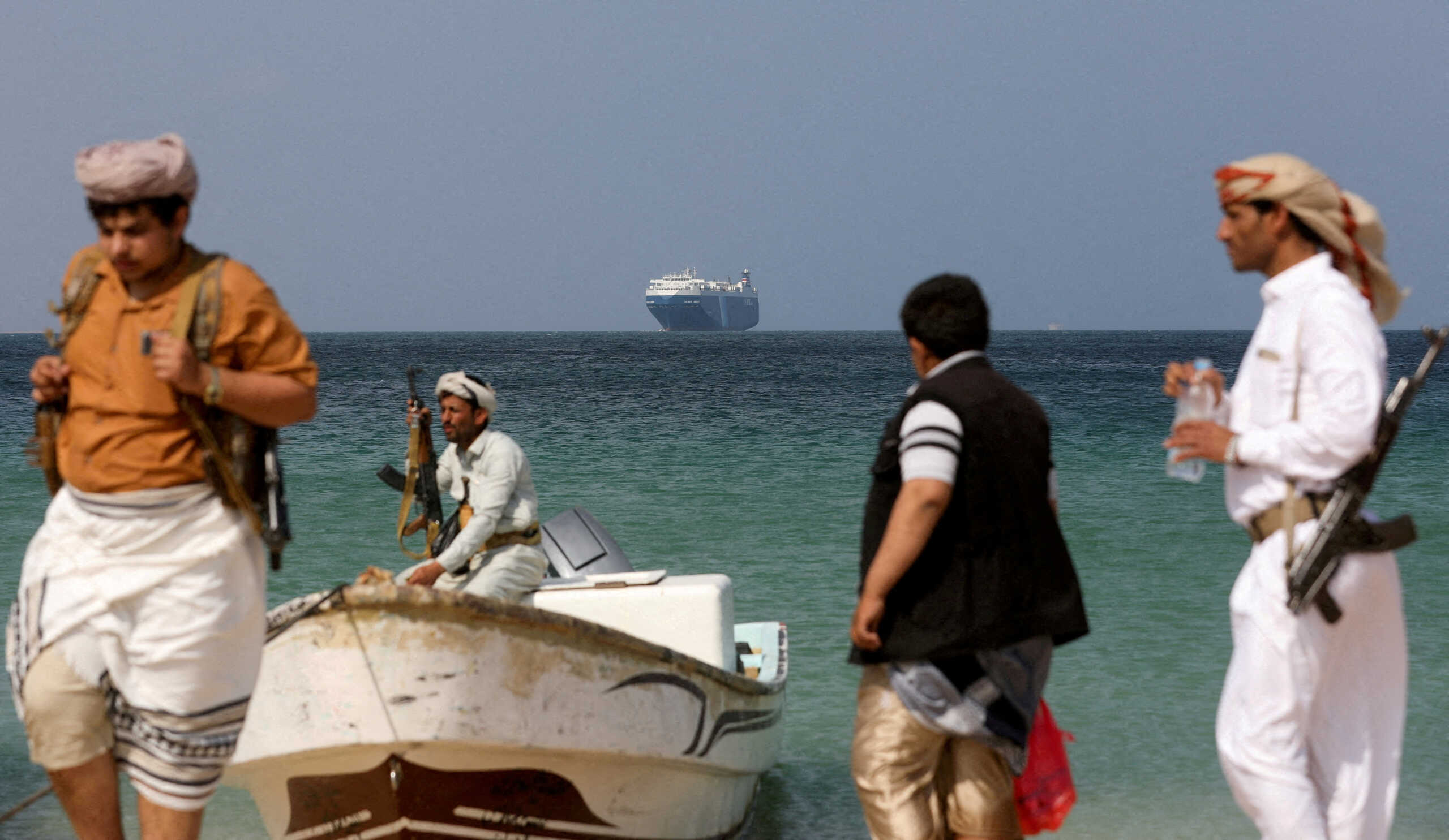 FILE PHOTO: Armed men stand on the beach as the Galaxy Leader commercial ship, seized by Yemen's Houthis last month, is anchored off the coast of al-Salif, Yemen, December 5, 2023. REUTERS