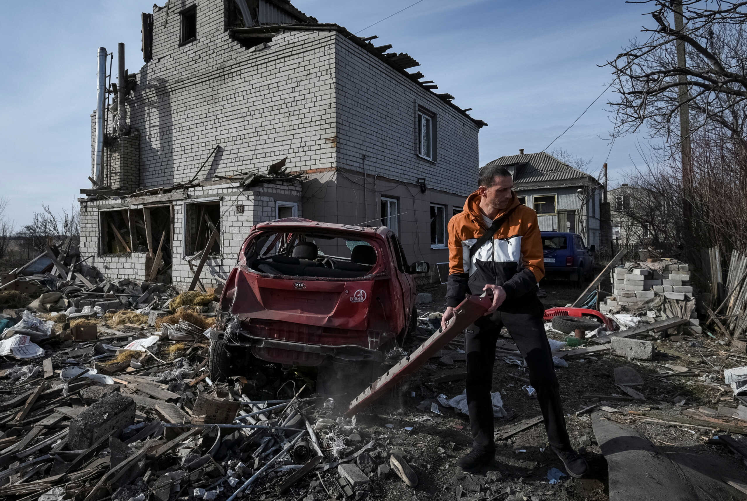 A local resident prepares a damaged car to be towed, near a residential building damaged during a Russian drone strike, amid Russia's attack on Ukraine, in Dnipro, Ukraine February 26, 2024. REUTERS