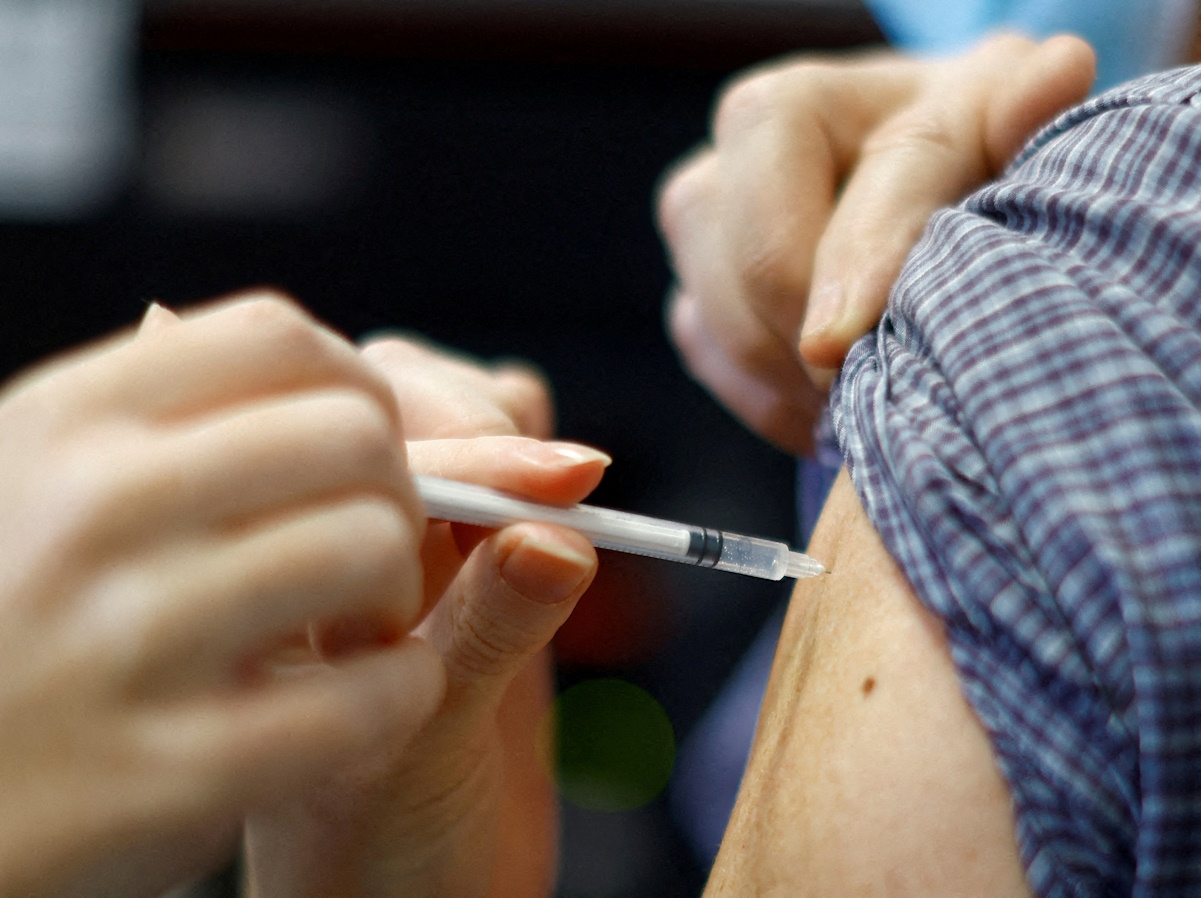 FILE PHOTO: A medical worker administers a dose of the "Cominarty" Pfizer-Bivalent coronavirus disease (COVID-19) vaccine to a patient at a vaccination centre in Nice, December 7, 2022. REUTERS
