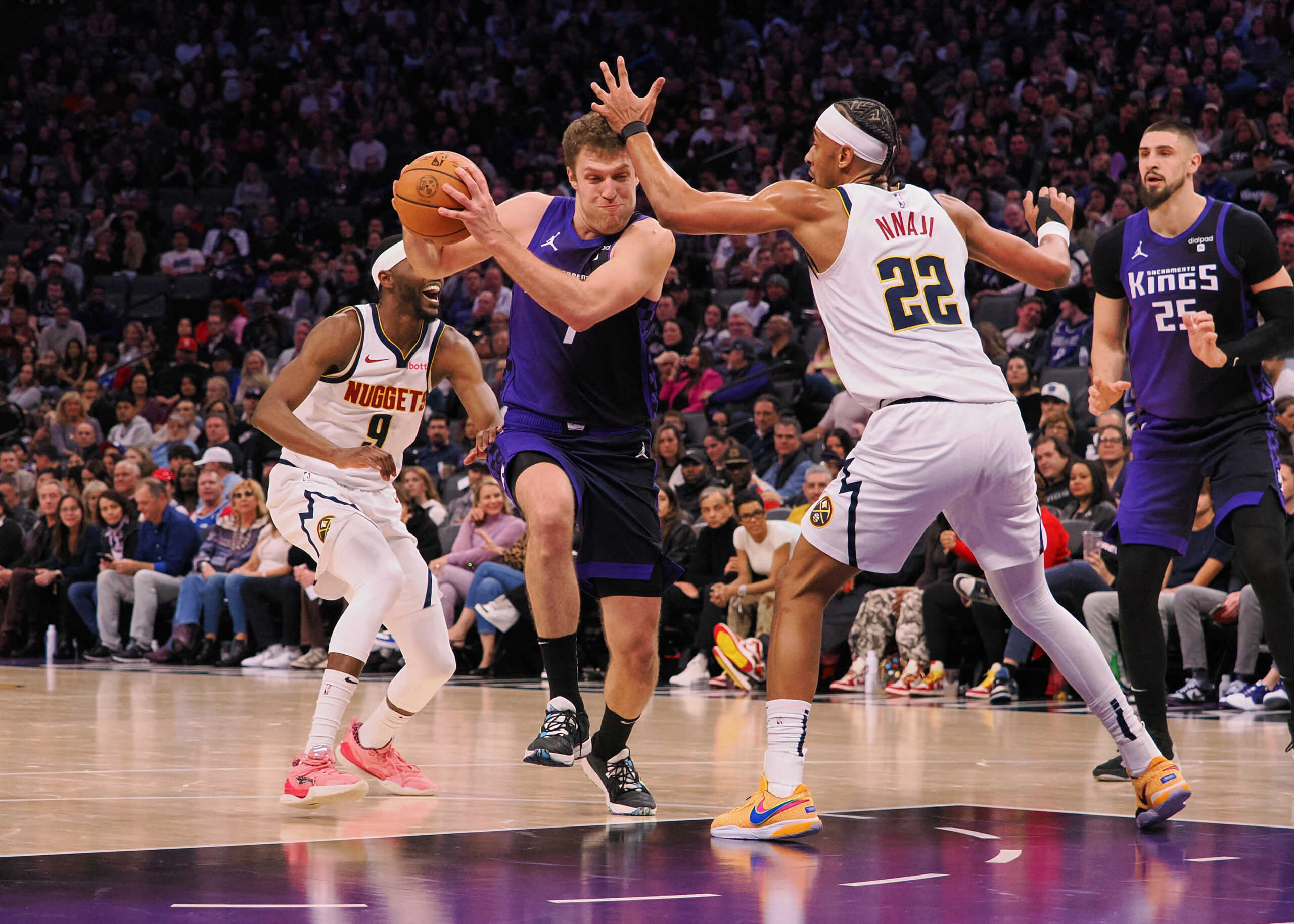 Feb 9, 2024; Sacramento, California, USA; Sacramento Kings forward Sasha Vezenkov (7) drives in between Denver Nuggets guard Justin Holiday (9) and forward Zeke Nnaji (22) during the fourth quarter at Golden 1 Center. Mandatory Credit: Kelley L Cox-USA TODAY Sports
