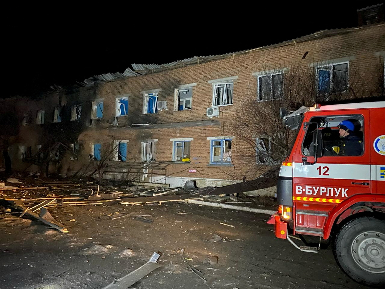 A view shows a fire truck next to a building damaged following a bomb blast, amid Russia's attack on Ukraine, in a location given as Velykyi Burluk, Kharkiv, Ukraine, in this handout image released on February 1, 2024. State Emergency Service Of Ukraine