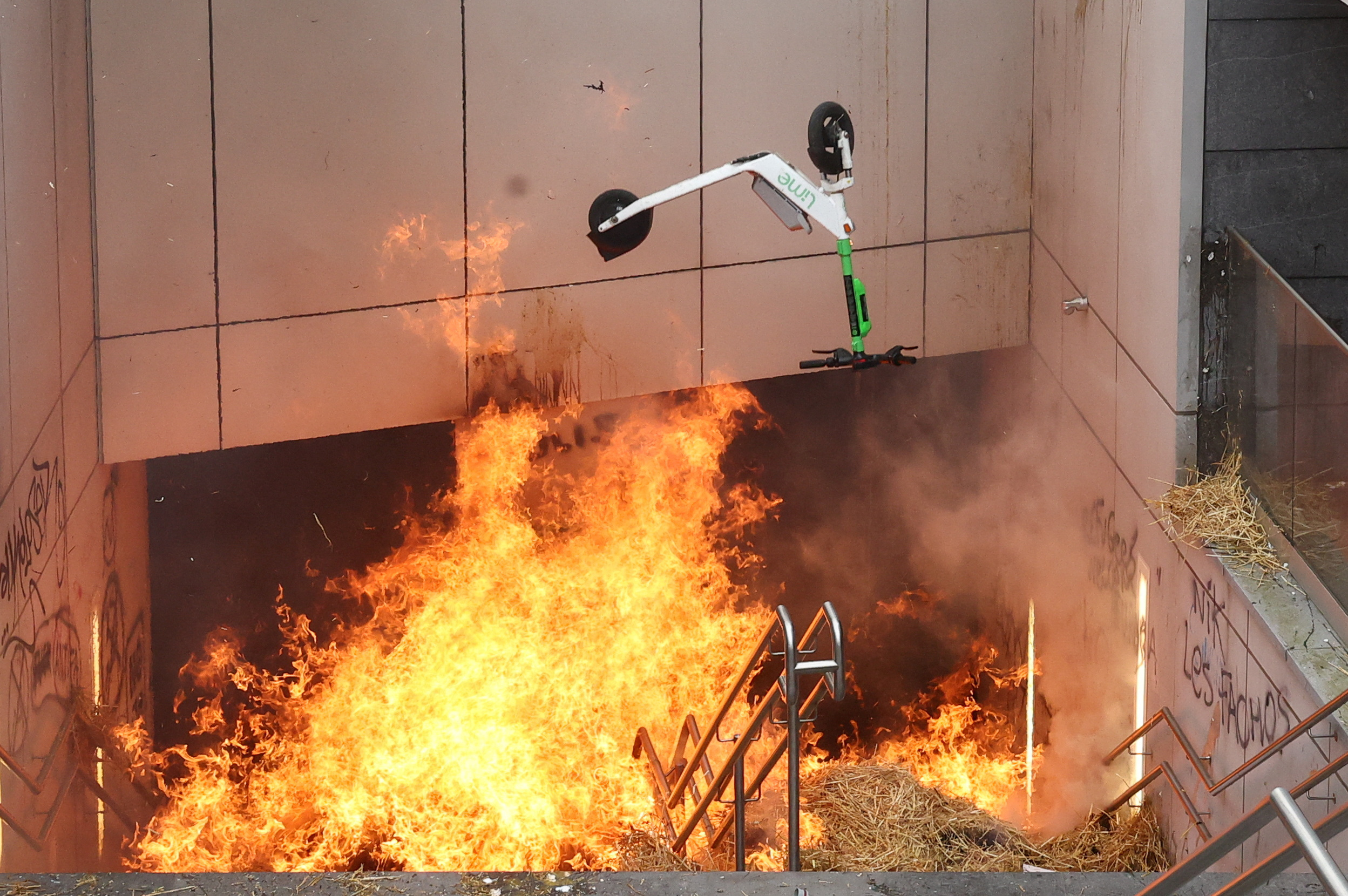 An electric scooter is thrown into the fire during a protest by Belgian farmers over price pressures, taxes and green regulation, on the day of an EU agriculture ministers' meeting in Brussels, Belgium March 26, 2024. REUTERS