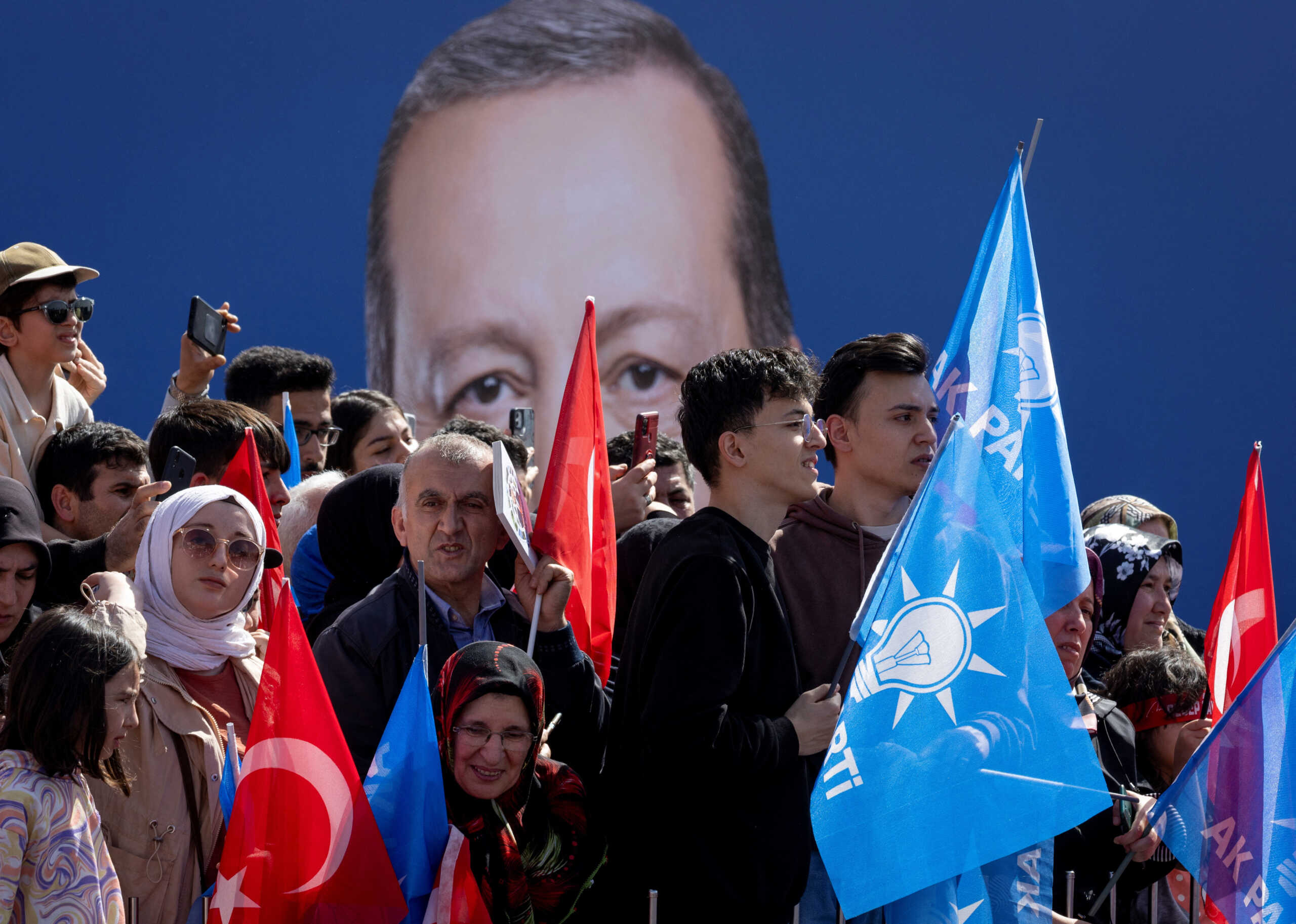 Supporters of Turkey's President Tayyip Erdogan listen to his speech as they hold flags during a rally ahead of the local elections in Istanbul, Turkey March 30, 2024. REUTERS