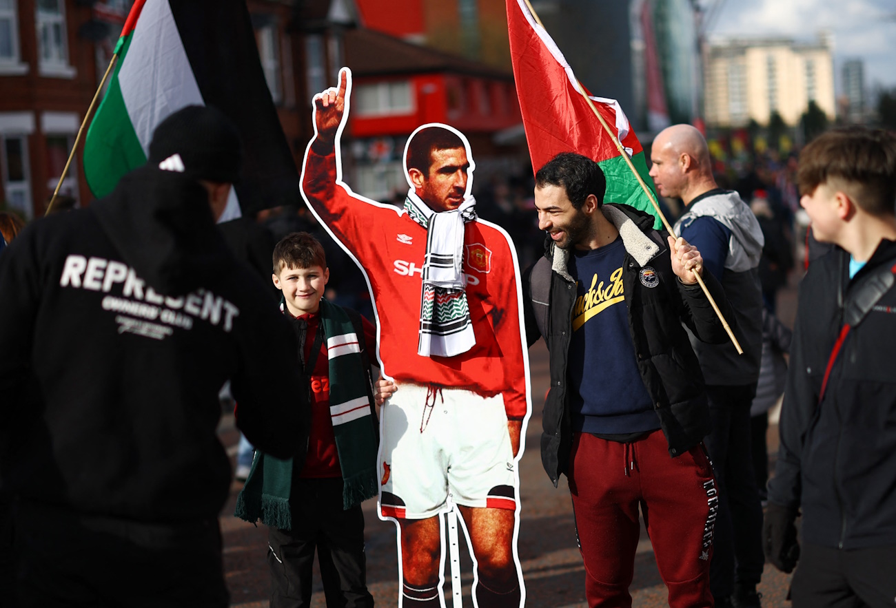 Soccer Football - Premier League - Manchester United v Fulham - Old Trafford, Manchester, Britain - February 24, 2024 Fans carrying the flag of Palestine and a cardboard cutout of former player Eric Cantona are pictured outside the stadium before the match REUTERS