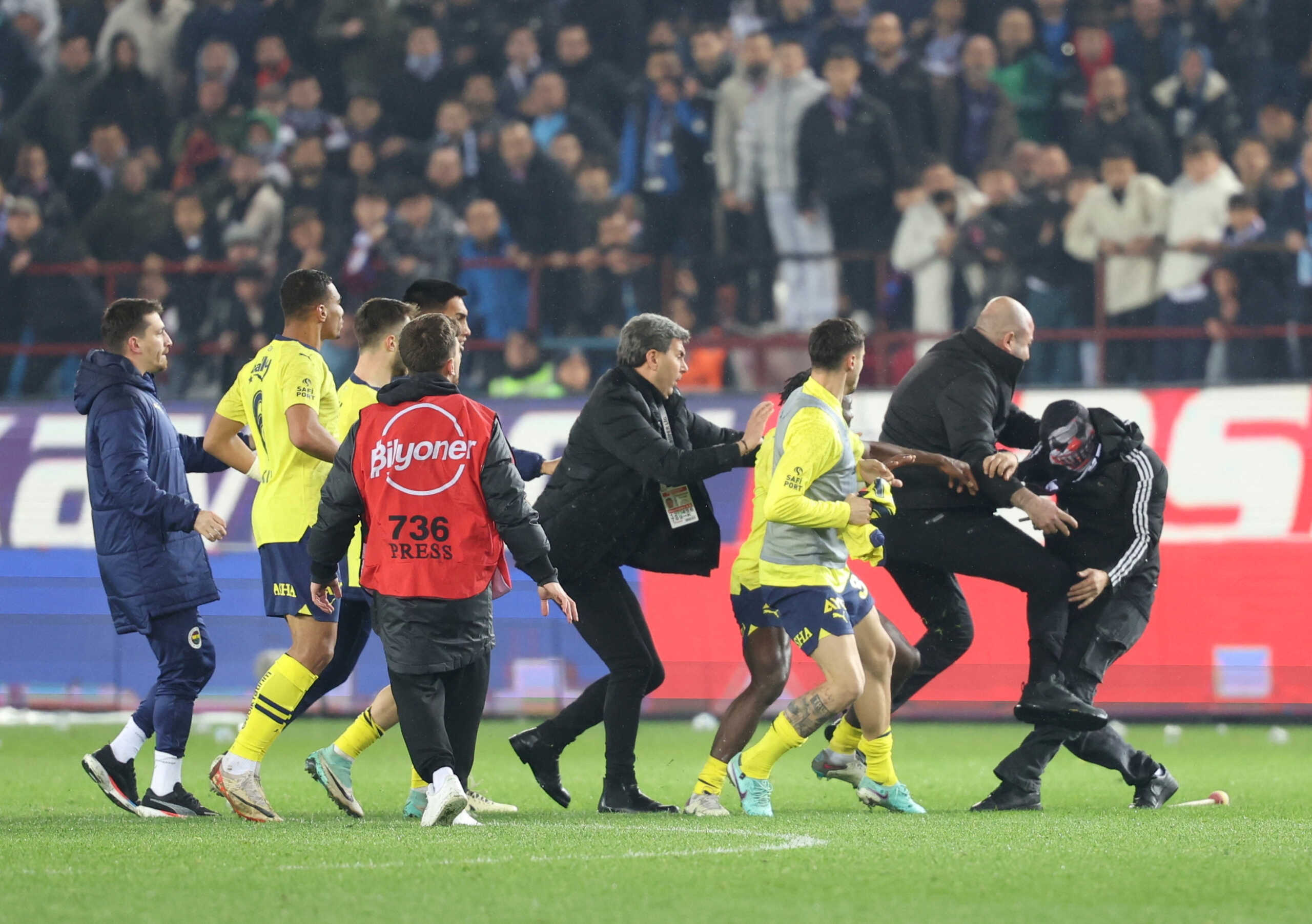 Soccer Football - Super Lig - Trabzonspor v Fenerbahce - Papara Park, Trabzon, Turkey - March 17, 2024   A Trabzonspor fan invades the pitch and clashes with Fenerbahce players and security staff after the match. REUTERS
