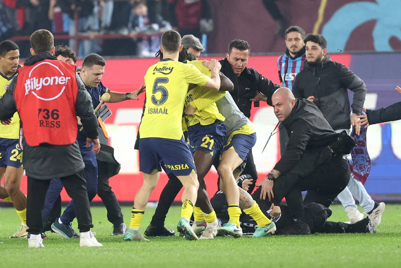 Soccer Football - Super Lig - Trabzonspor v Fenerbahce - Papara Park, Trabzon, Turkey - March 17, 2024   Trabzonspor fans invade the pitch and clash with Fenerbahce players and security staff after the match. REUTERS
