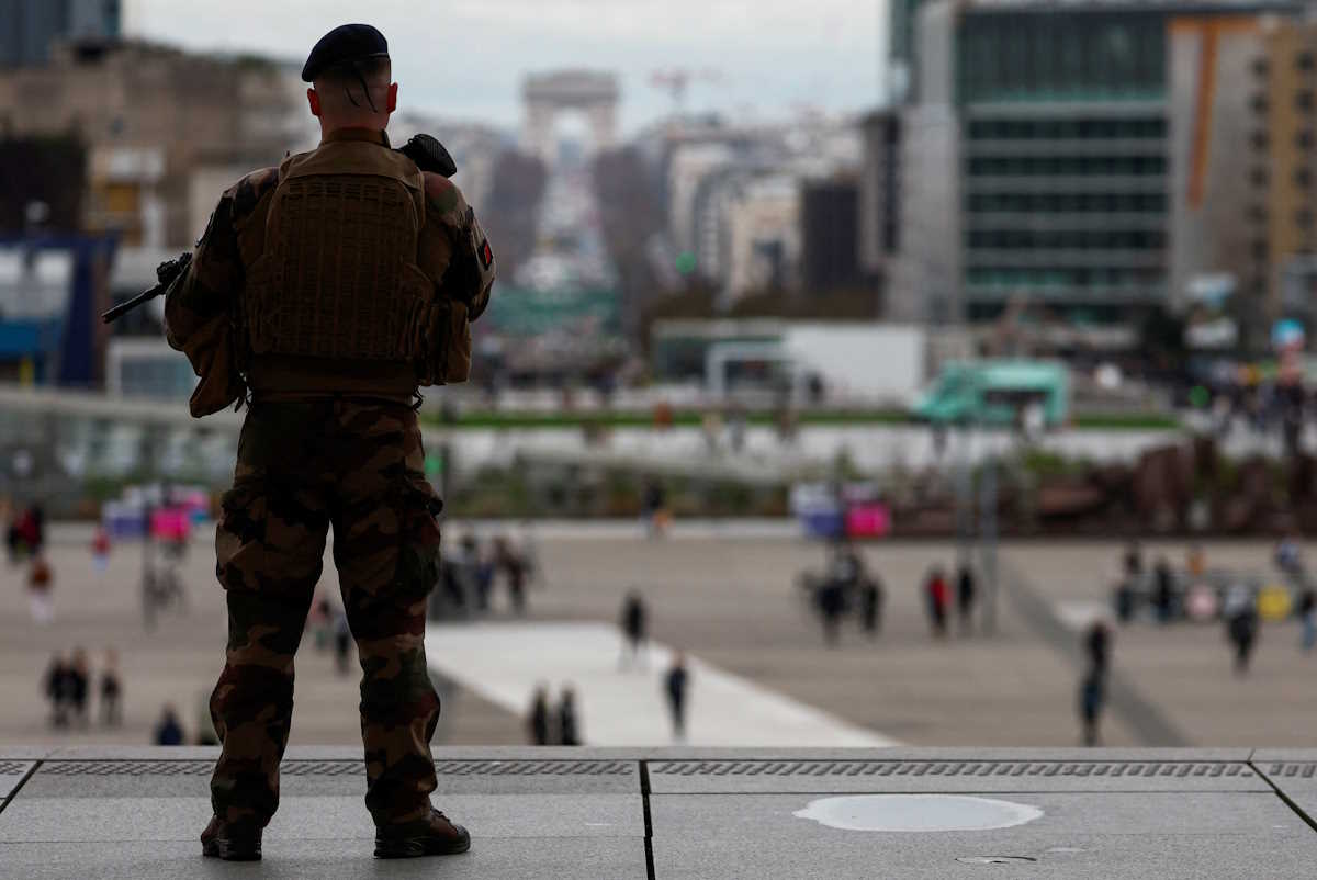 An armed French soldier patrols at the esplanade of La Defense as part of the "Vigipirate" security plan in the financial and business district in La Defense, Puteaux near Paris, France, March 13, 2024. The Arc de Triomphe is seen in the background. REUTERS