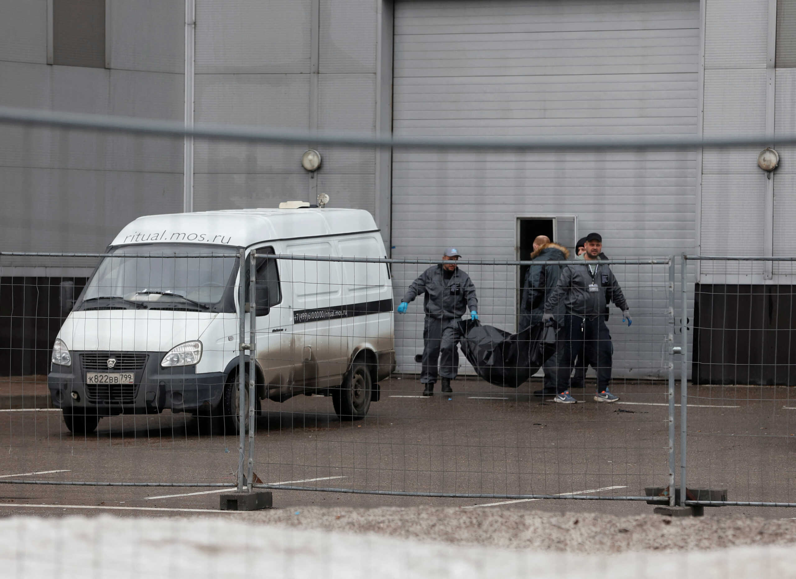 Specialists carry the body of a victim of a shooting attack at the Crocus City Hall concert venue into a vehicle, in the Moscow Region, Russia, March 23, 2024. REUTERS