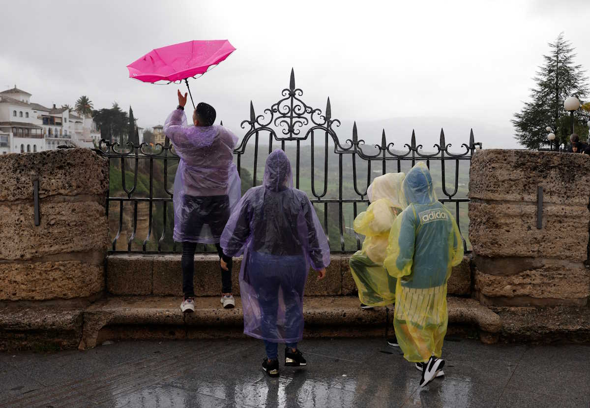 A tourist's umbrella blows upside down as he and his family use raincoats to cover themselves from the heavy rain and high winds as Storm Nelson hits Spain during the Holy Week in Ronda, Spain March 28, 2024. REUTERS