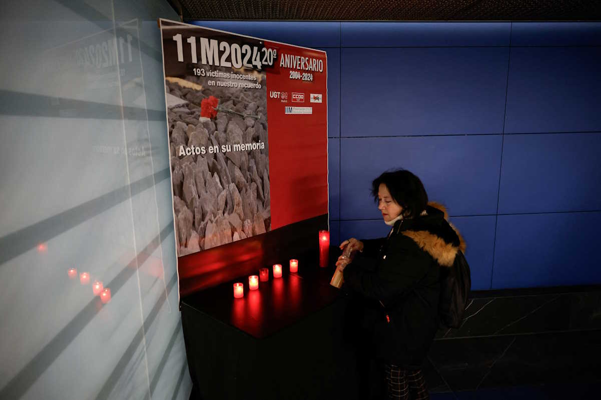 A woman lights a candle at Atocha train station on the day of a memorial for the March 11, 2004 train bombings, on its 20th anniversary in Madrid, Spain, March 11, 2024. REUTERS