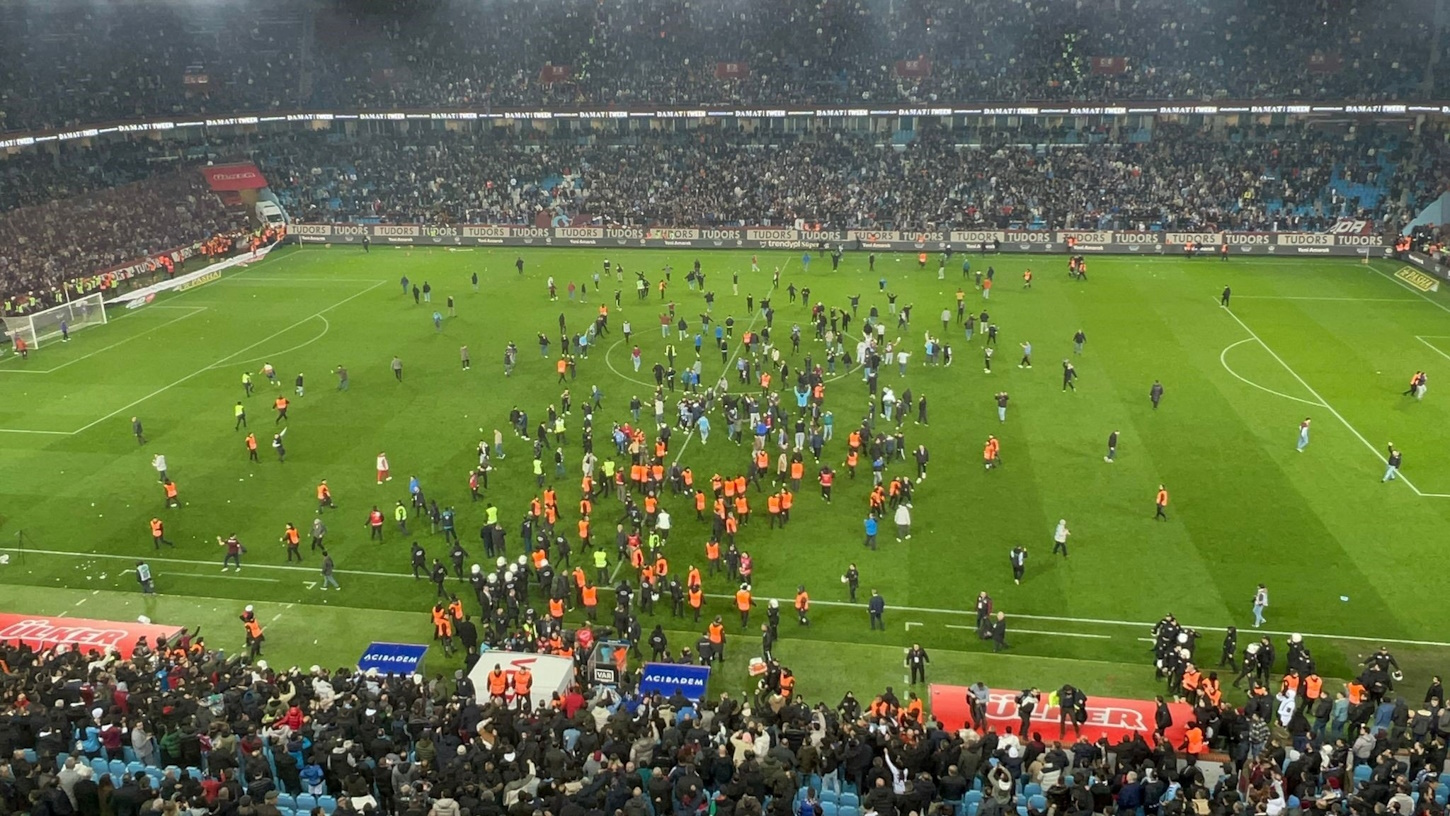 Soccer Football - Super Lig - Trabzonspor v Fenerbahce - Papara Park, Trabzon, Turkey - March 17, 2024 Trabzonspor fans invade the pitch and clash with Fenerbahce players and security staff after the match. REUTERS