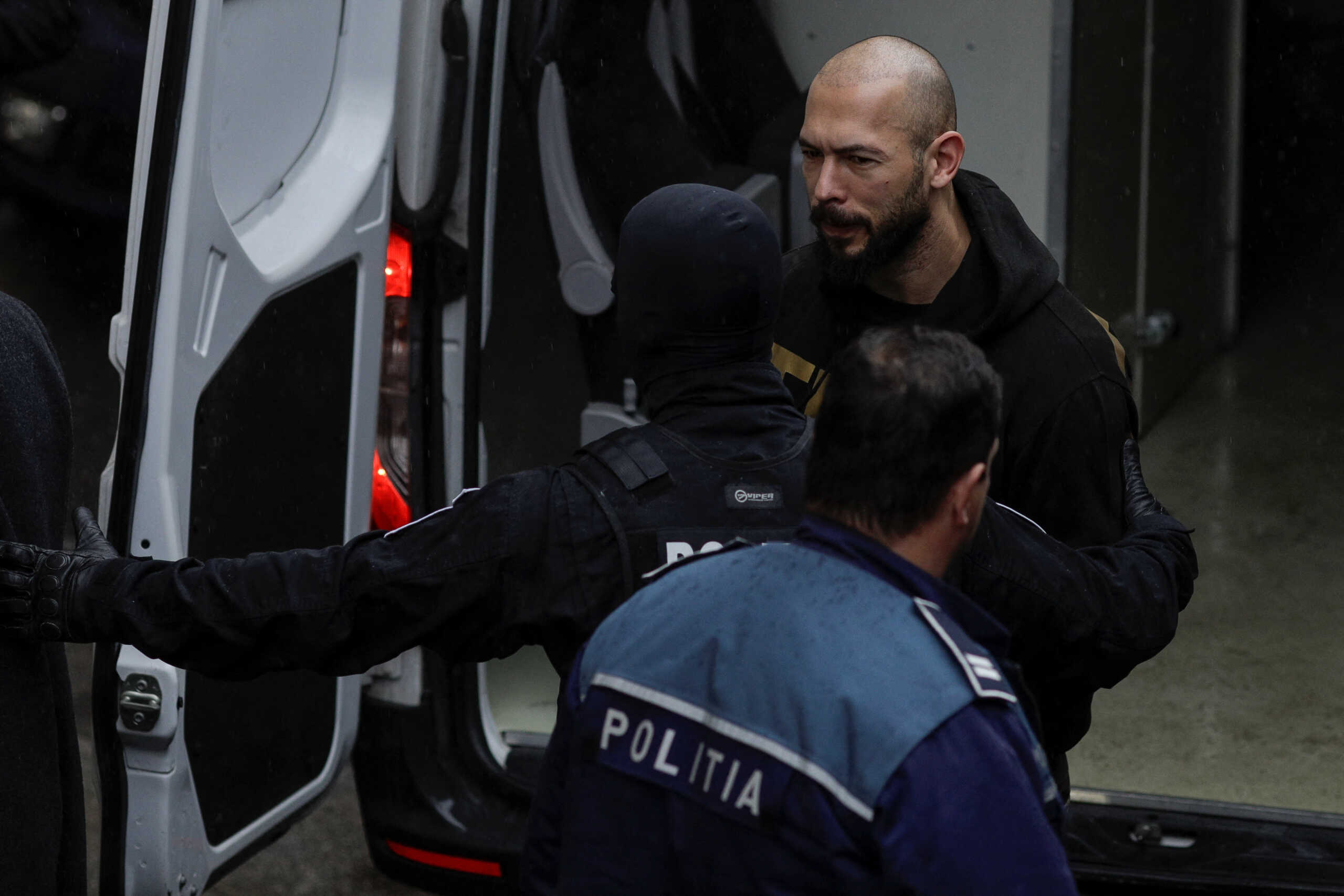 Andrew Tate and Tristan Tate (not pictured) are brought in by police officers to appear in front of a judge at the Bucharest Court of Appeal, in Bucharest, Romania, March 12, 2024. Inquam Photos