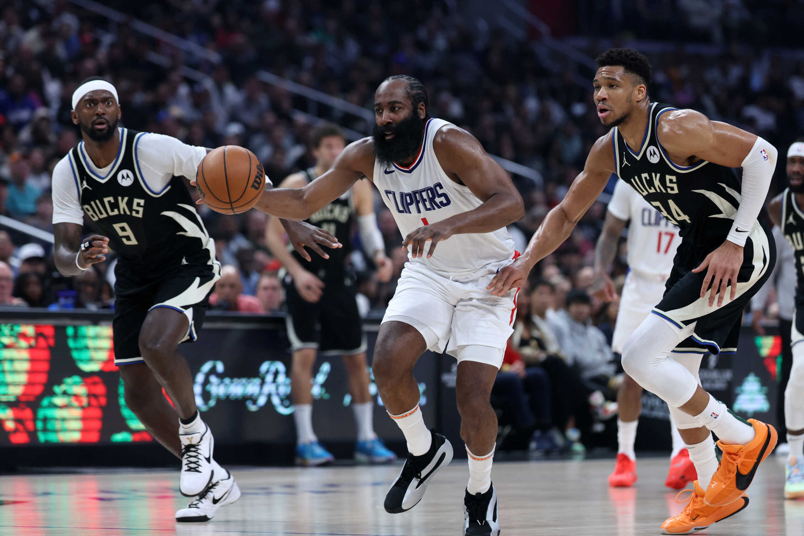 Mar 10, 2024; Los Angeles, California, USA;  Los Angeles Clippers guard James Harden (1) dribbles the ball between Milwaukee Bucks forward Bobby Portis (9) and forward Giannis Antetokounmpo (34) during the second quarter at Crypto.com Arena. Mandatory Credit: Kiyoshi Mio-USA TODAY Sports