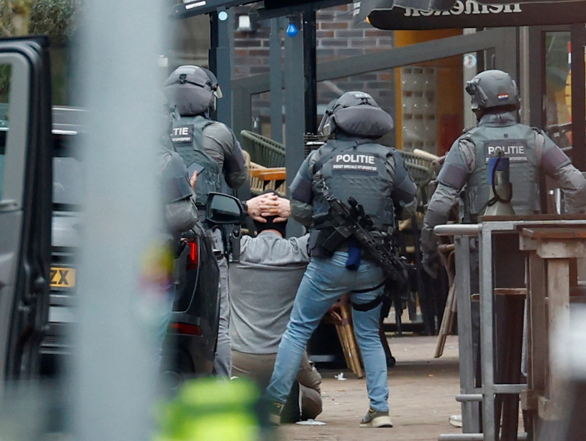 Dutch police officers detain a person near the Cafe Petticoat, where several people are being held hostage in Ede, Netherlands March 30, 2024.  REUTERS