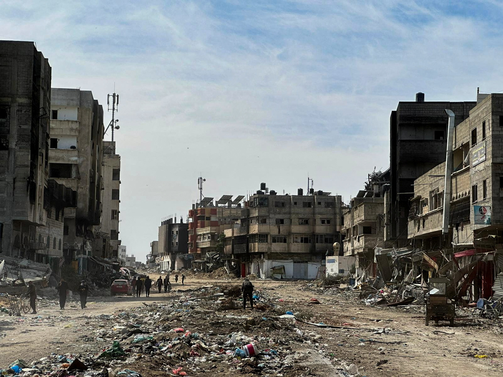 People walk near damaged houses at Zeitoun neighborhood after Israeli forces withdrew from the area, in Gaza City March 1, 2024. REUTERS