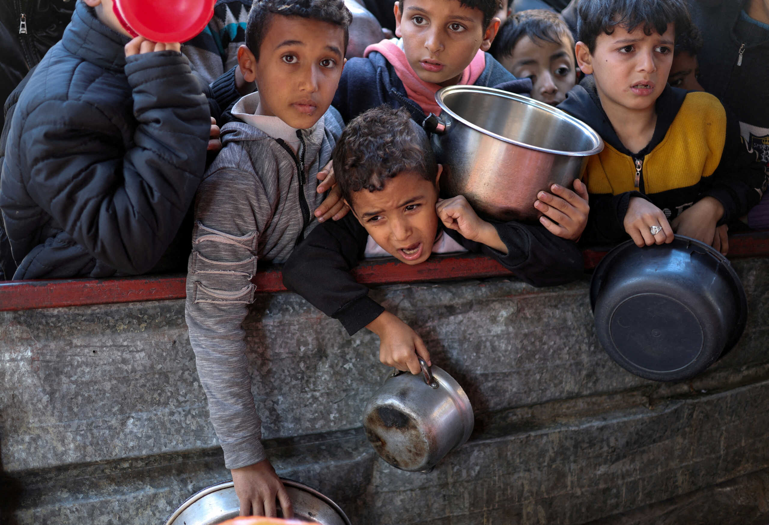 FILE PHOTO: Palestinian children wait to receive food cooked by a charity kitchen amid shortages of food supplies, as the ongoing conflict between Israel and the Palestinian Islamist group Hamas continues, in Rafah, in the southern Gaza Strip, February 5, 2024. REUTERS