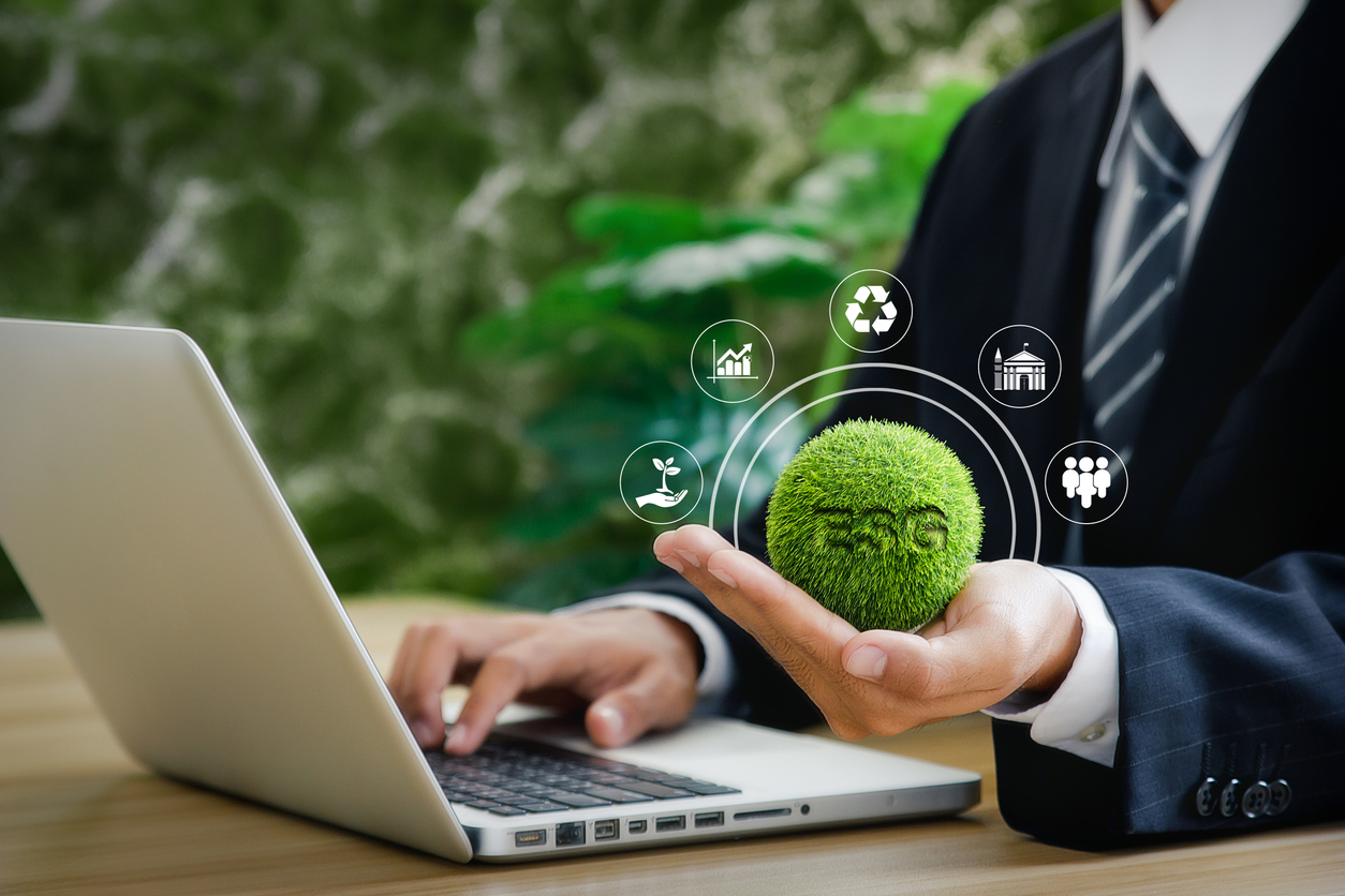 Businessman is using computer and holding ESG icon. Environment, Society and Governance. concept illustrated with icons with beautiful green bokeh background.